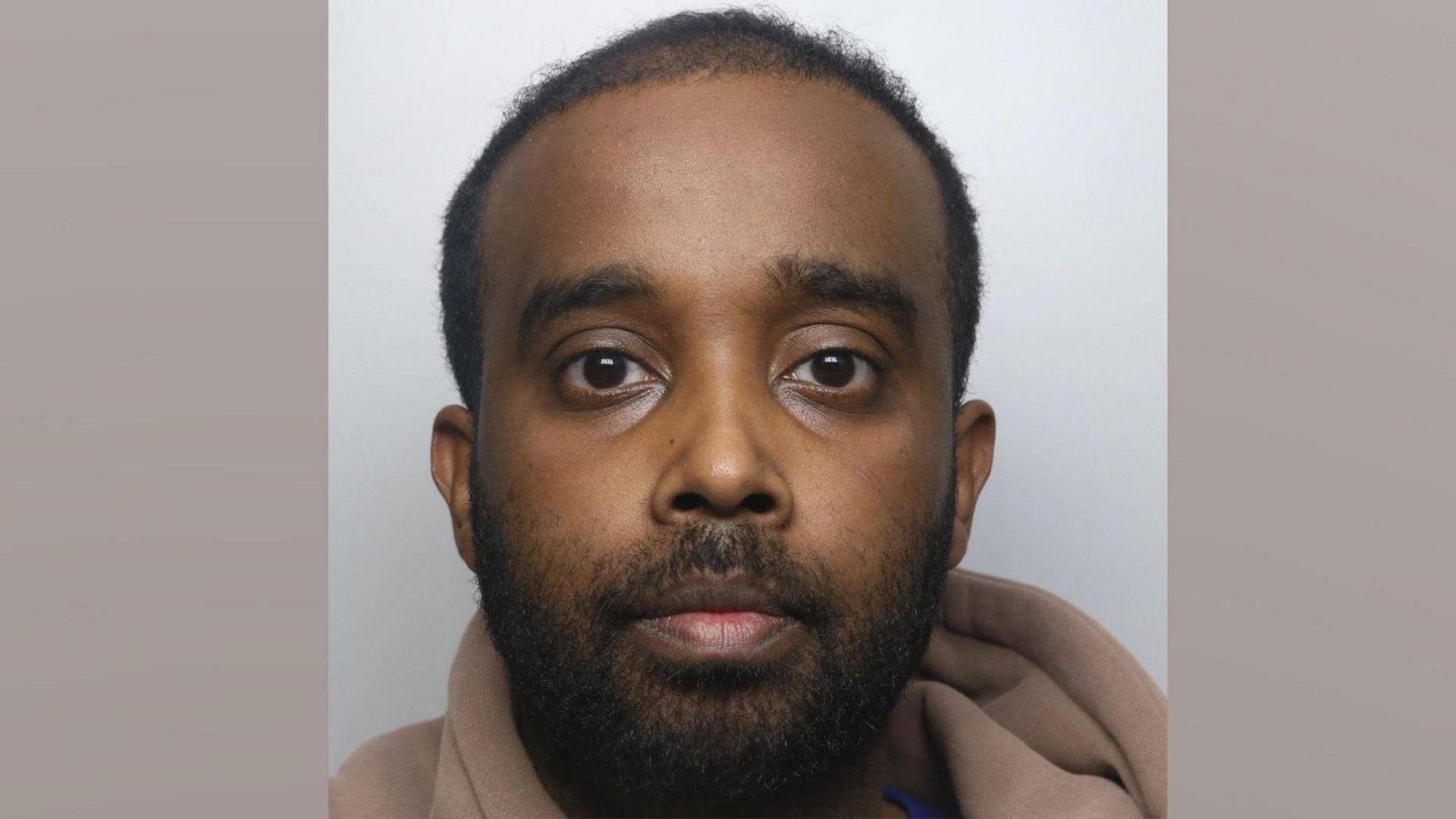 Abdirahiim Hassan is wearing a beige hoodie