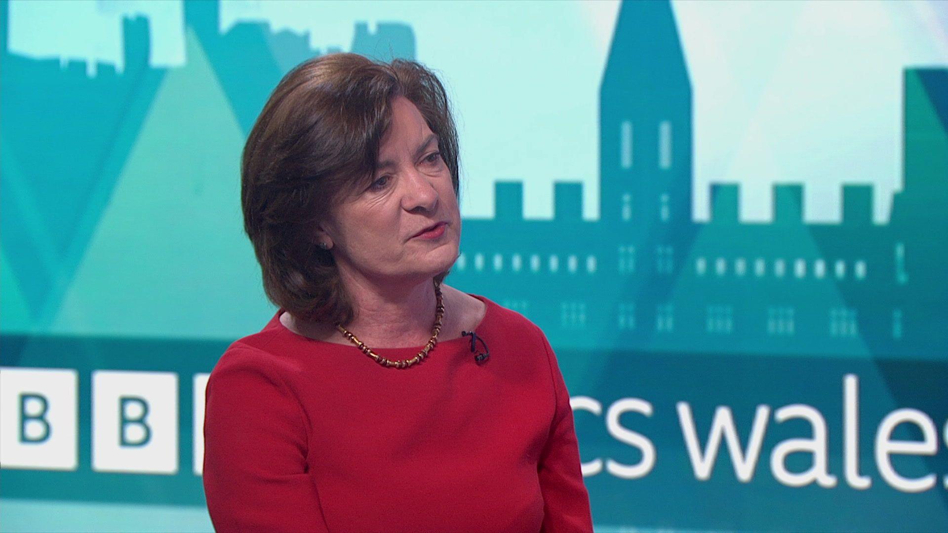 Eluned Morgan mewn gwisg goch yn cael ei holi ar raglen BBC Politics Wales