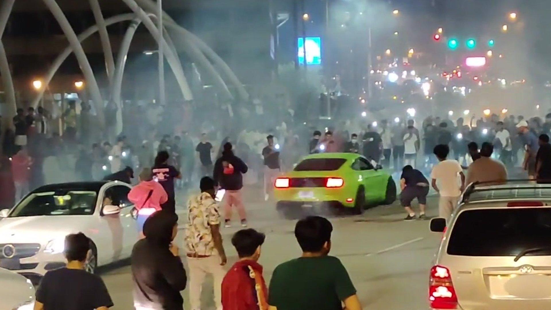 A screengrab from footage shows a green car spinning doughnuts on a bridge in Atlanta, blocking the flow of traffic