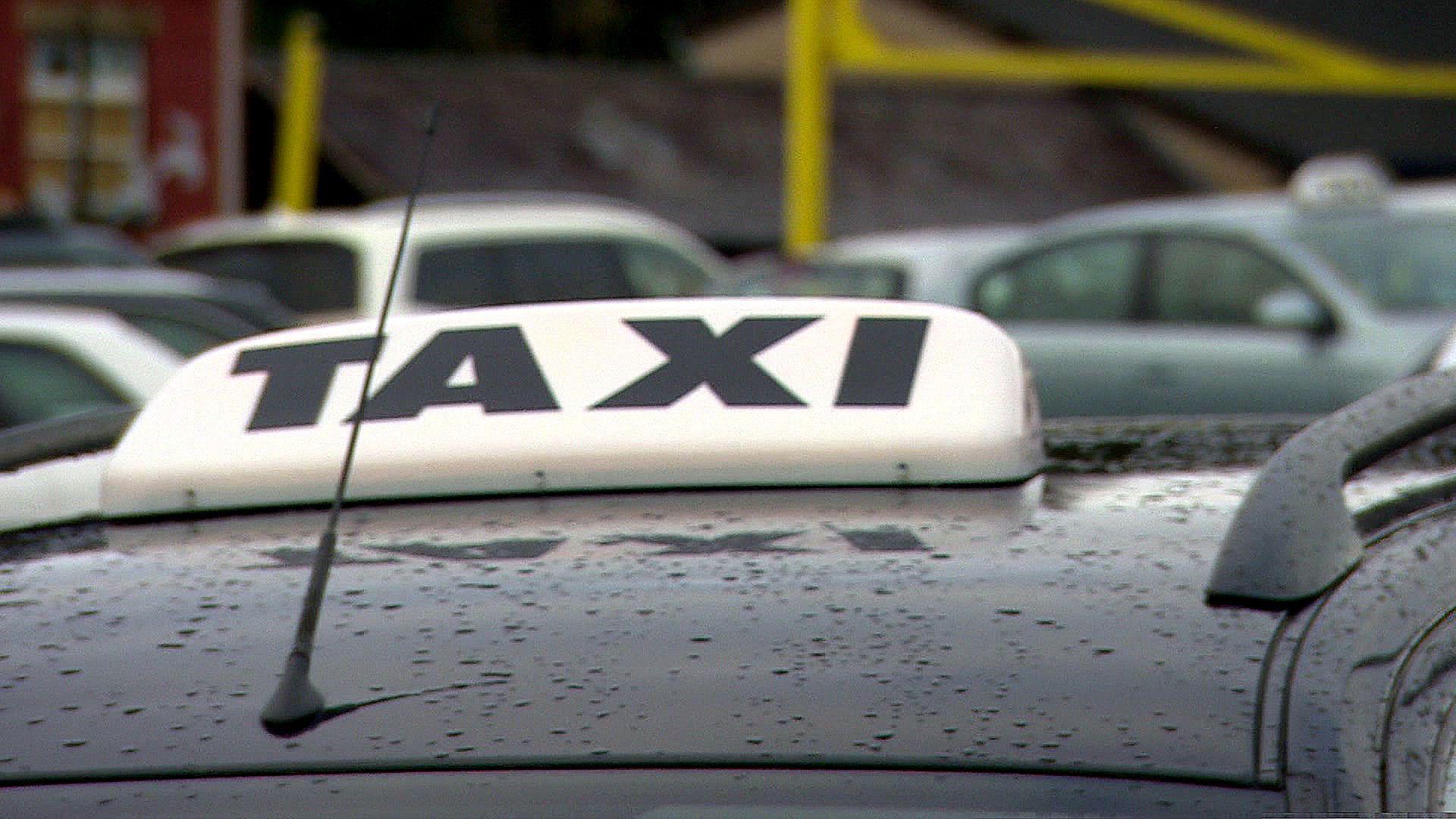 Stock image of a TAXI sign on the roof of a licensed mini cab.