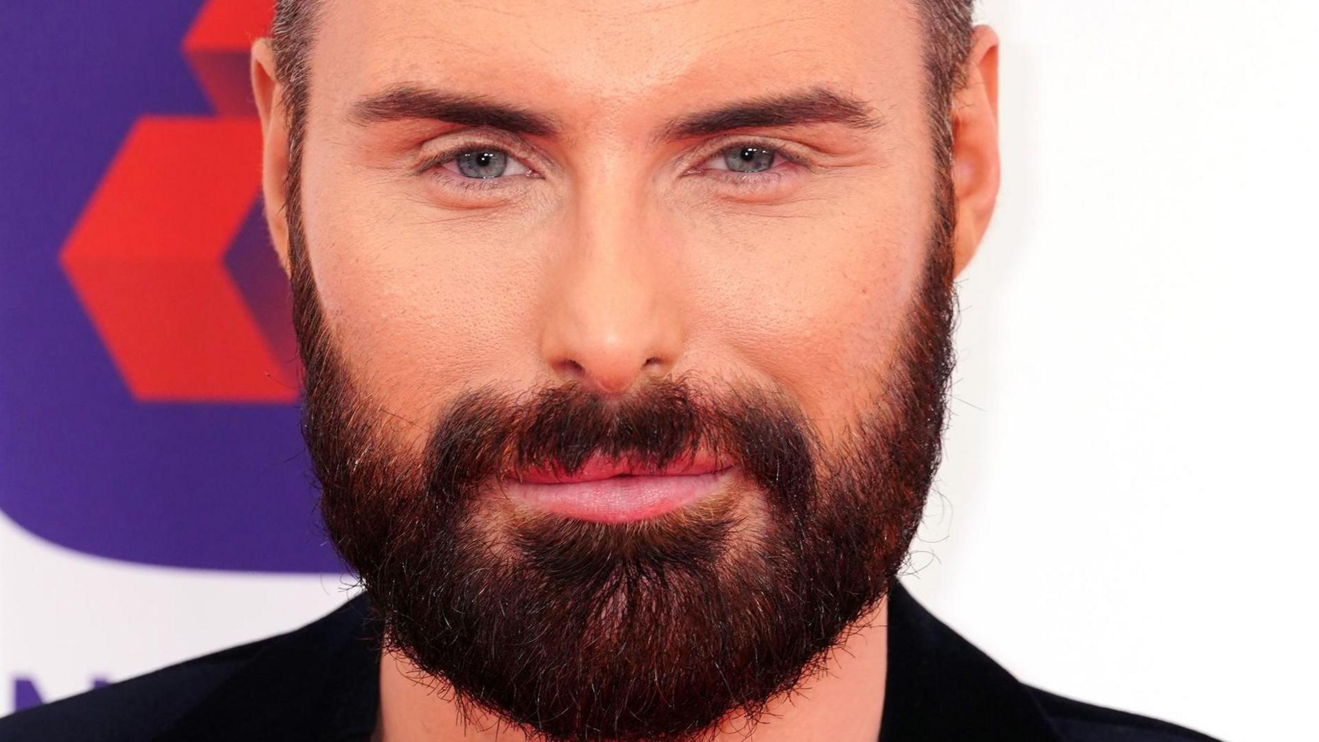 Rylan Clark, who has a black beard and is wearing a black smart jacket, attending the Prince's Trust Awards in 2023.