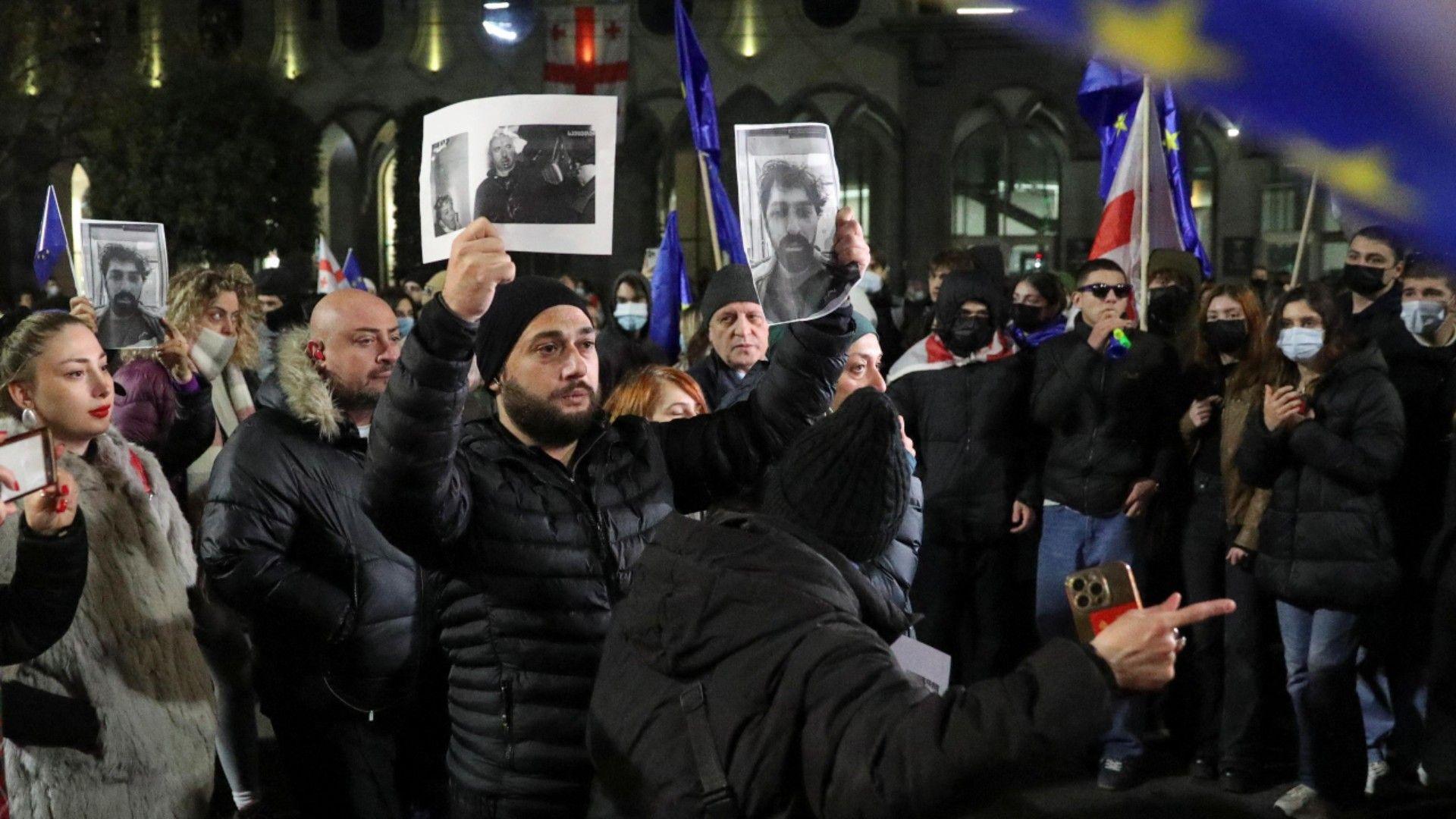 Protesters hold up photographs during demonstrations in Tbilisi 