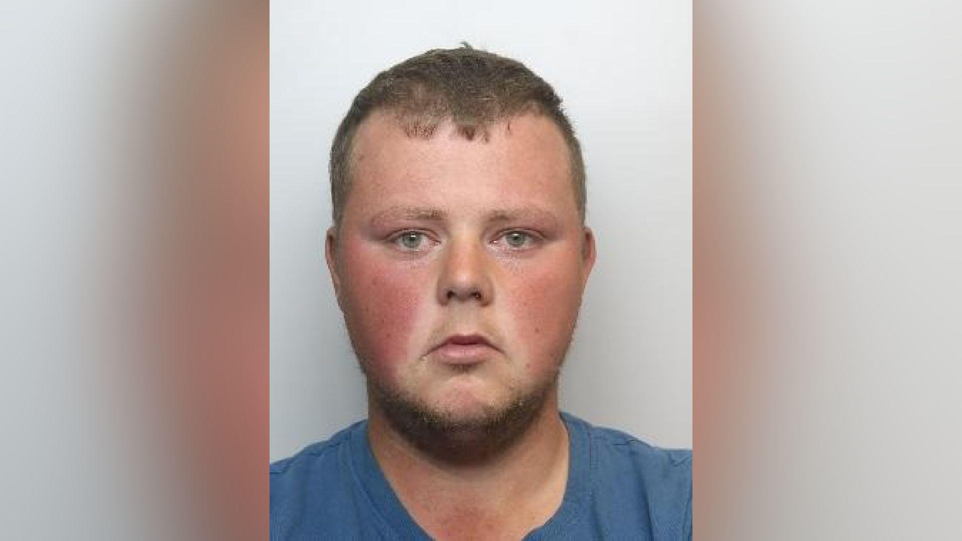 A mugshot of Mason Reddy, looking at the camera and wearing a blue t-shirt