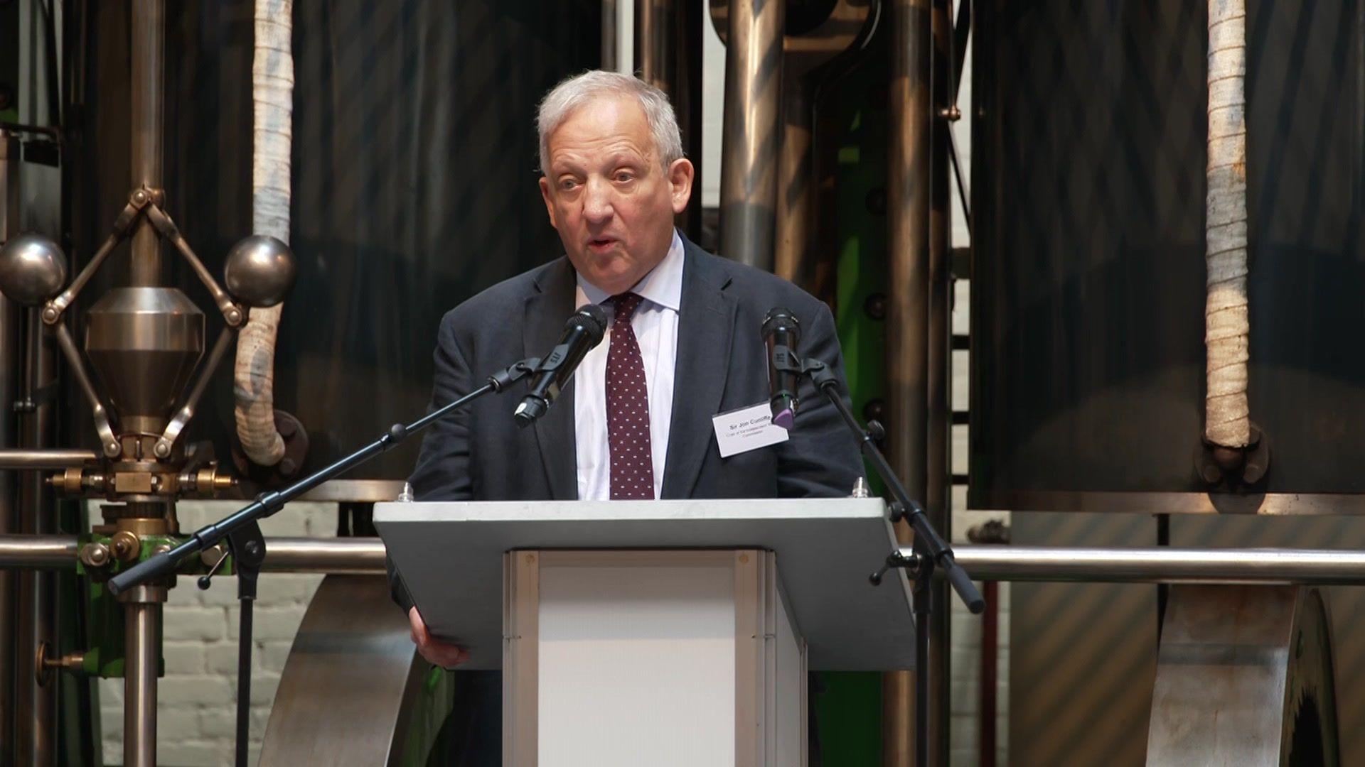 Syr Jon Cunliffe yn annerch cynhadledd i'r wasg ddydd Llun