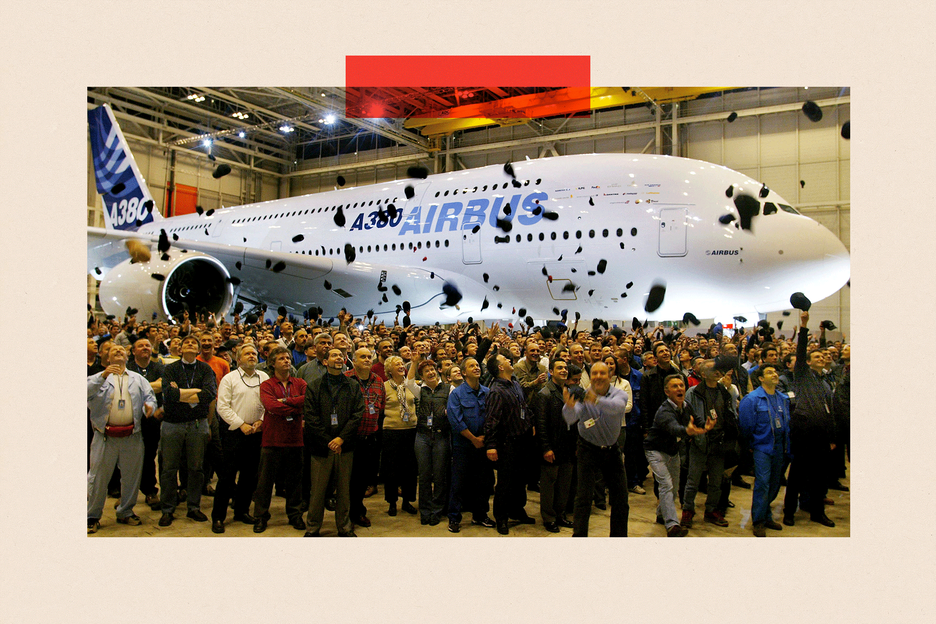 Airbus workers throw hats in the air in front of the new Airbus A380 superjumbo during its unveiling ceremony