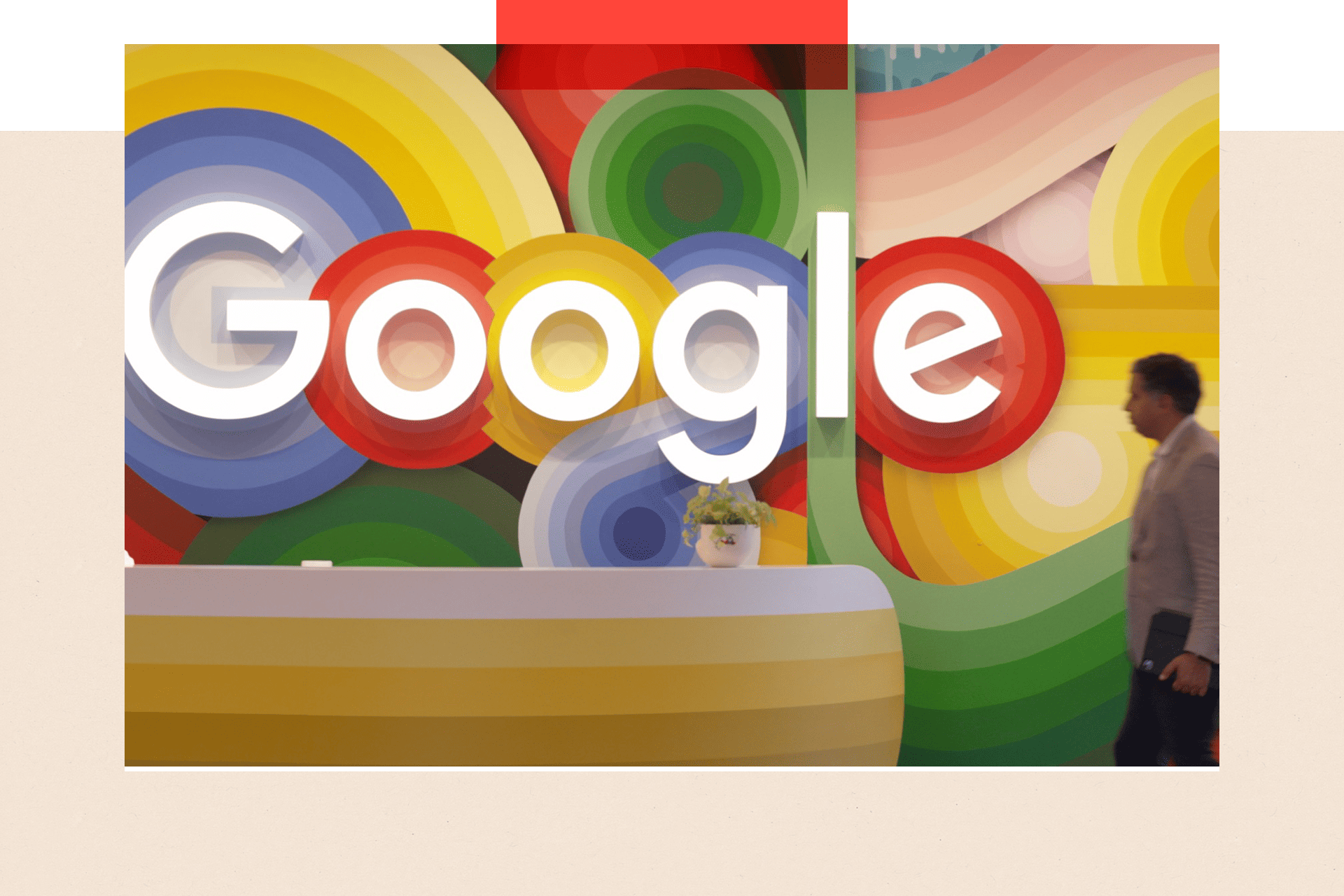 A blurred person passing a colourful Google sign