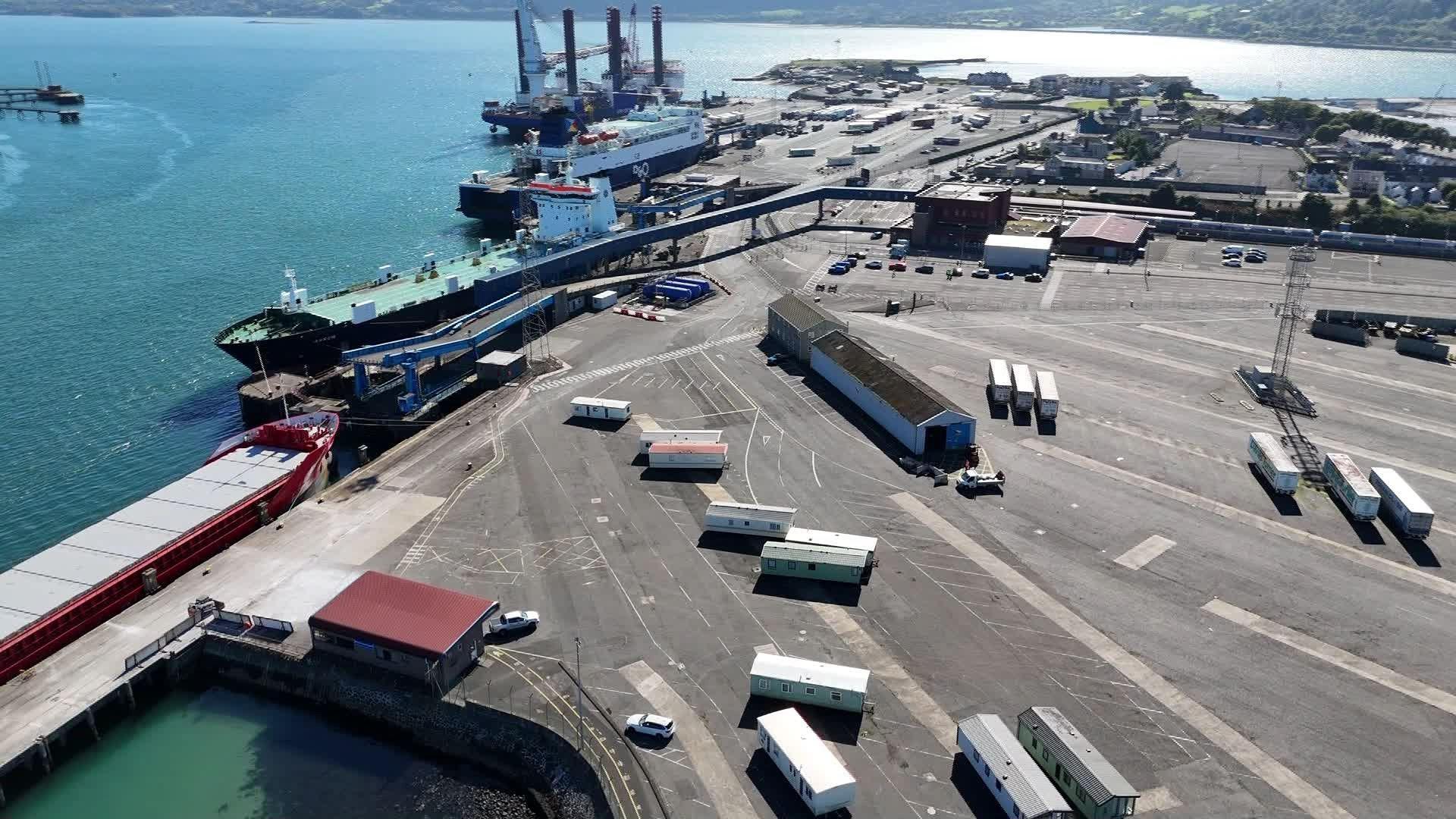 A drone image of the harbour loading bay. Cargo ships are parked alongside the concrete bay.