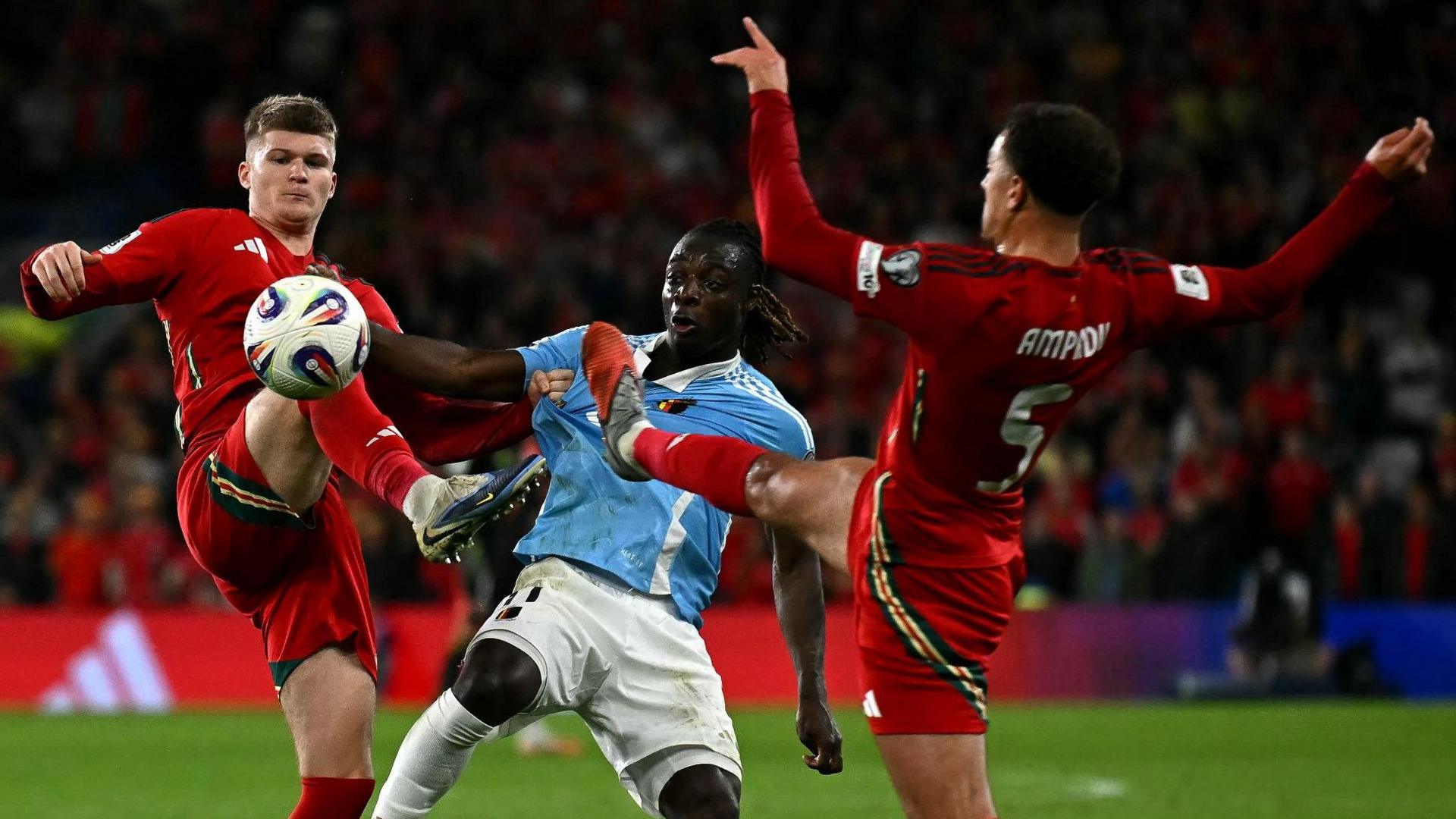 Wales' midfielder Jordan James (L) and Wales' defender Ethan Ampadu (R) battle for the ball with Belgium's Jeremy Doku 