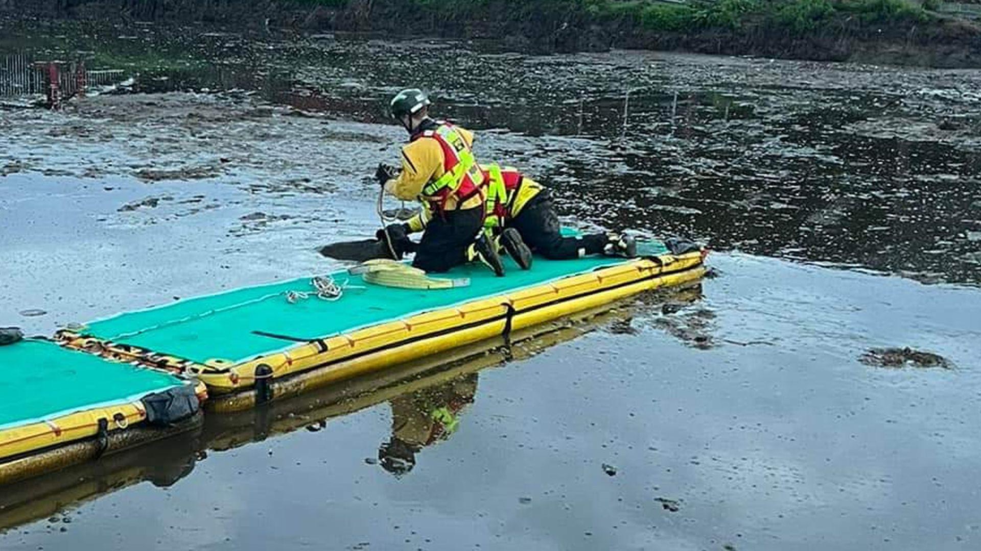 Rescuers on an inflatable platform in a slurry pit