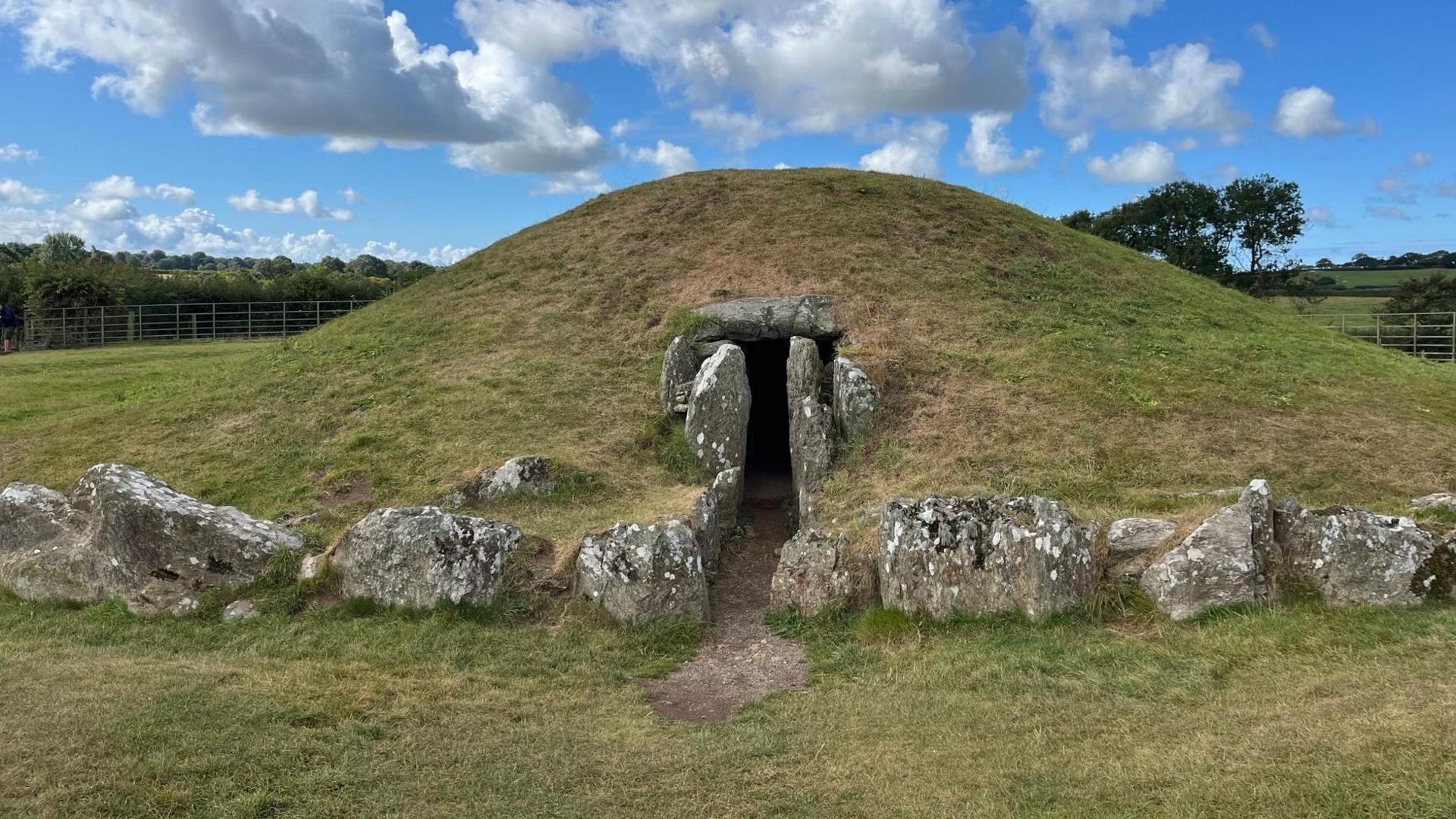 The stone entrance to Bryn Celli Ddu passage tomb on Anglesey, a large stone entrance is cut into a grassy mound dating back 5000 years.