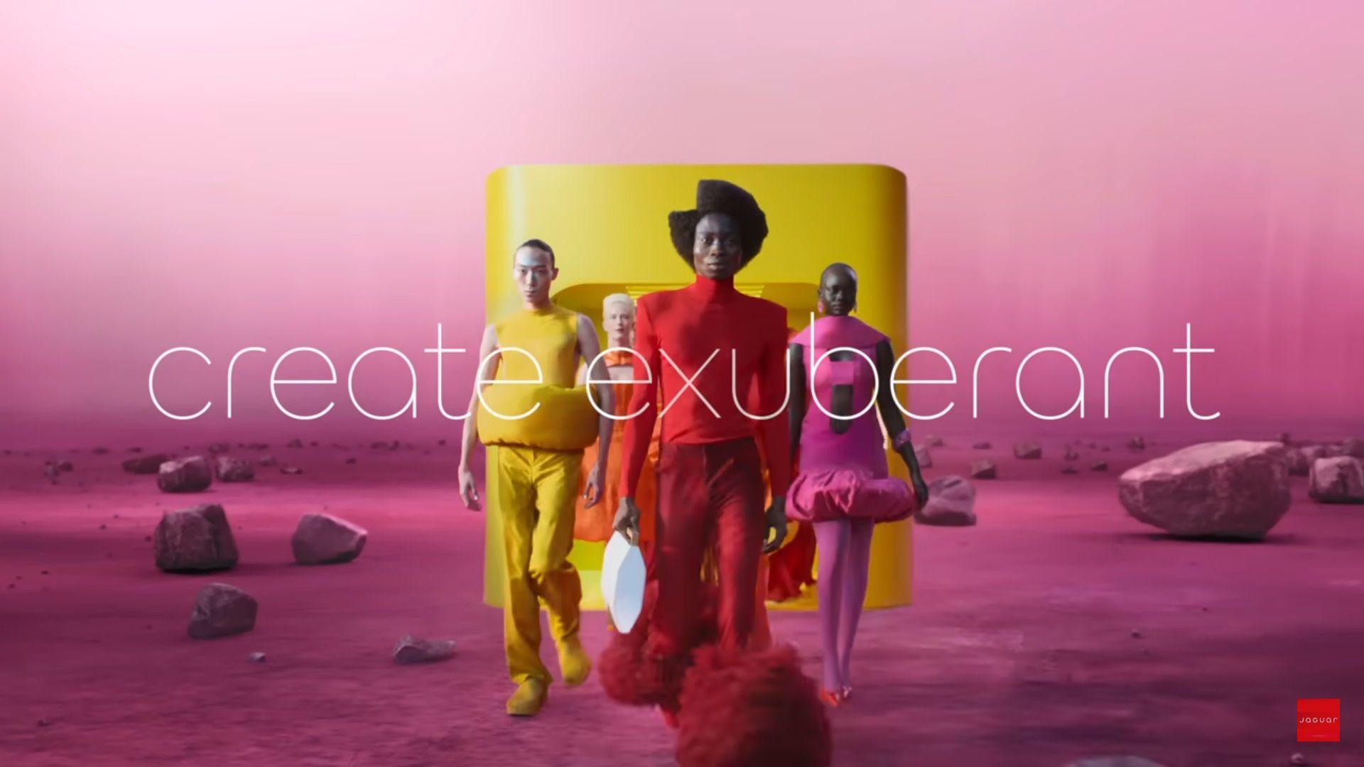 models in bright coloured clothes walk across a pink landscape