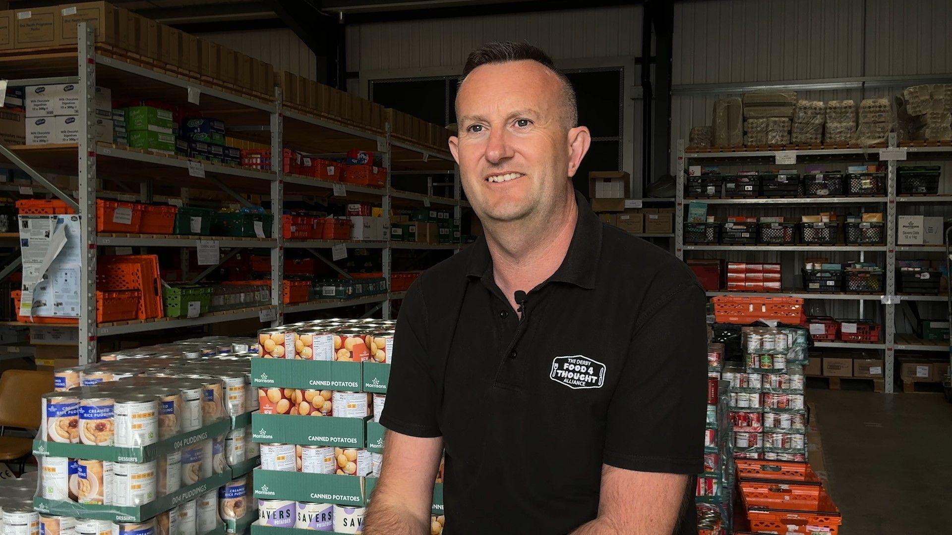 Paul Brookhouse sat inside a food bank warehouse