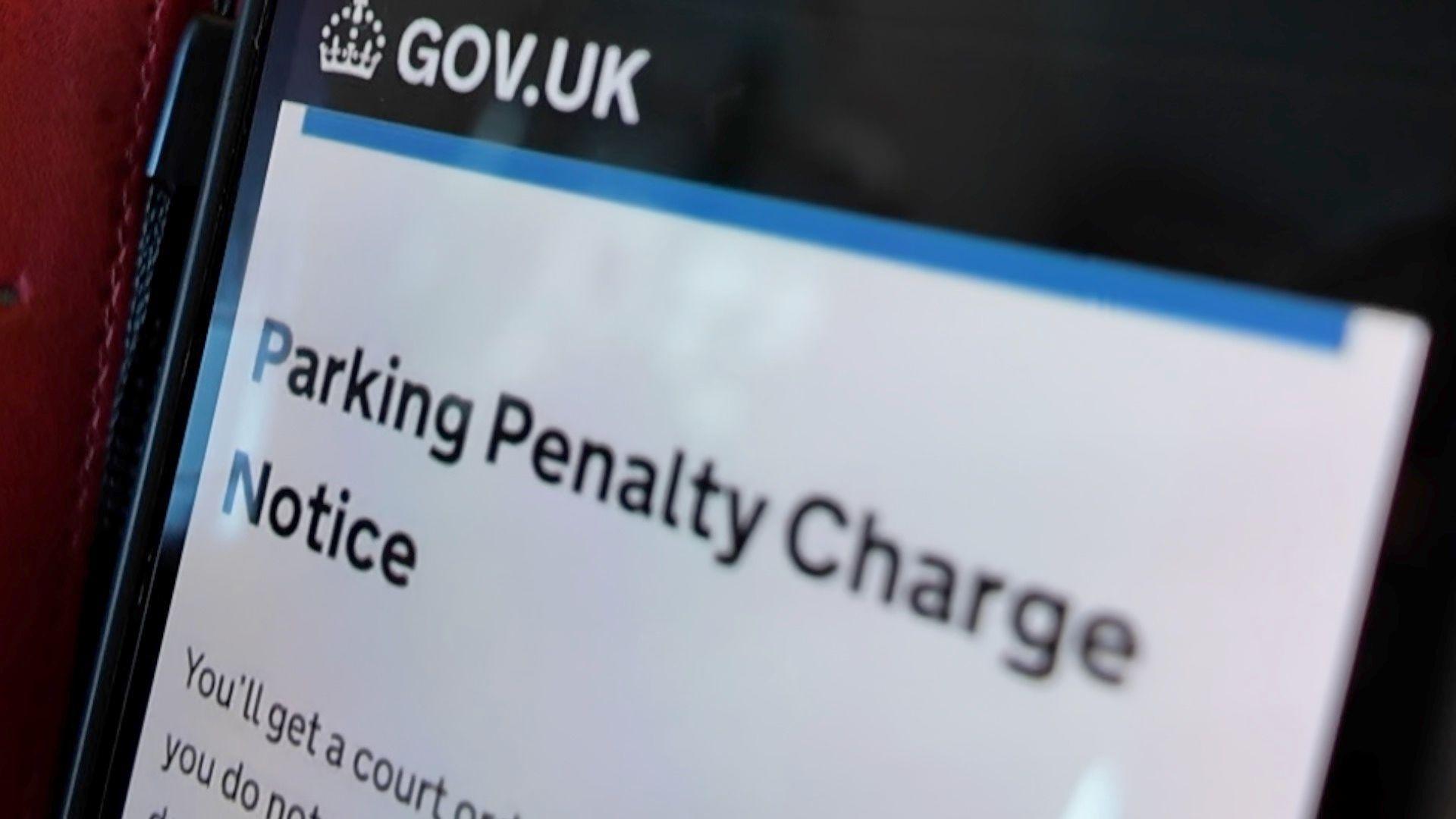 A close-up of a phone which has a scam parking penalty message from a fake government website