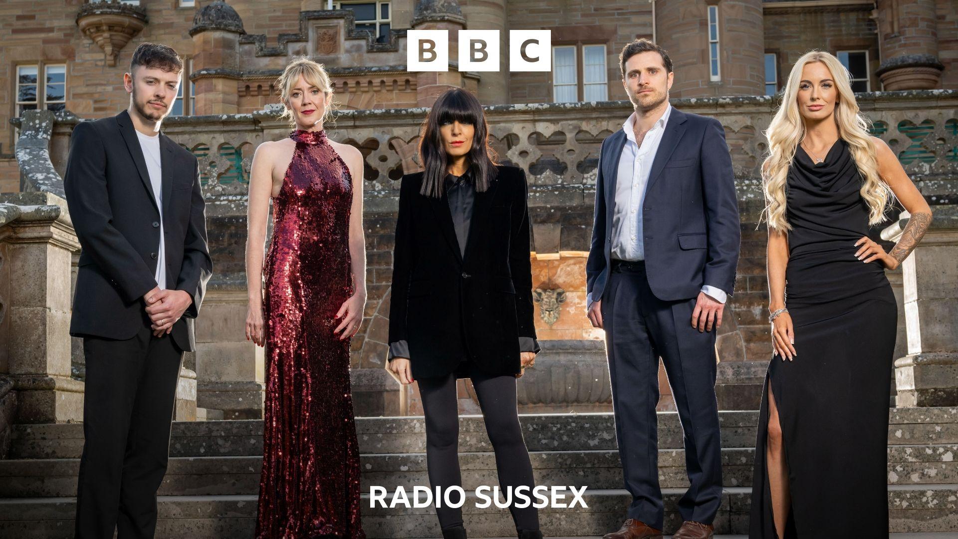 Claudia Winkleman stands with 4 finalists from series 3 of The Traitors. They are standing on the steps outside a castle and all dressed in evening wear. The contestants are 2 men and 2 women.