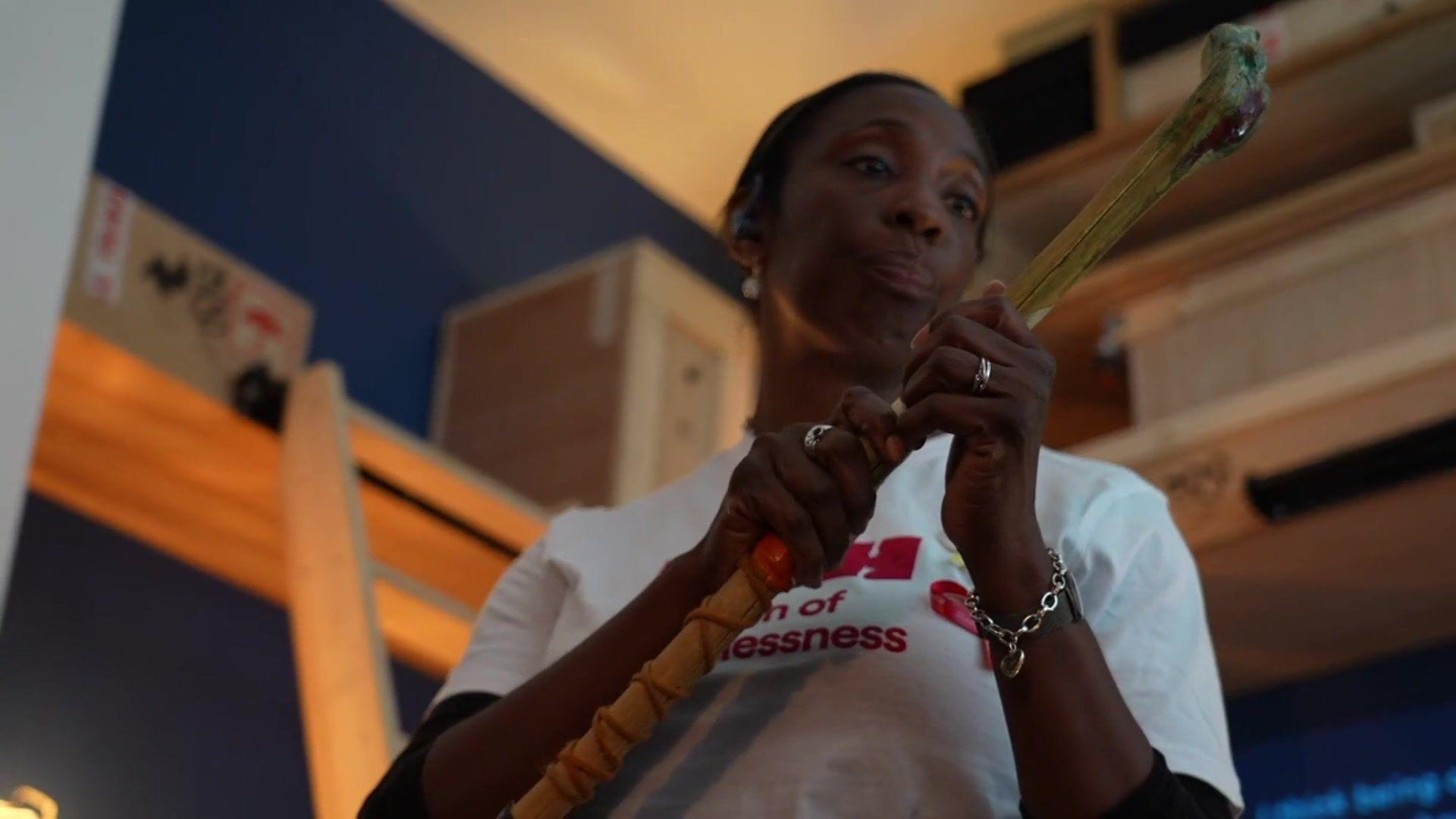 Lisa Ogun shows visitors the beloved walking stick