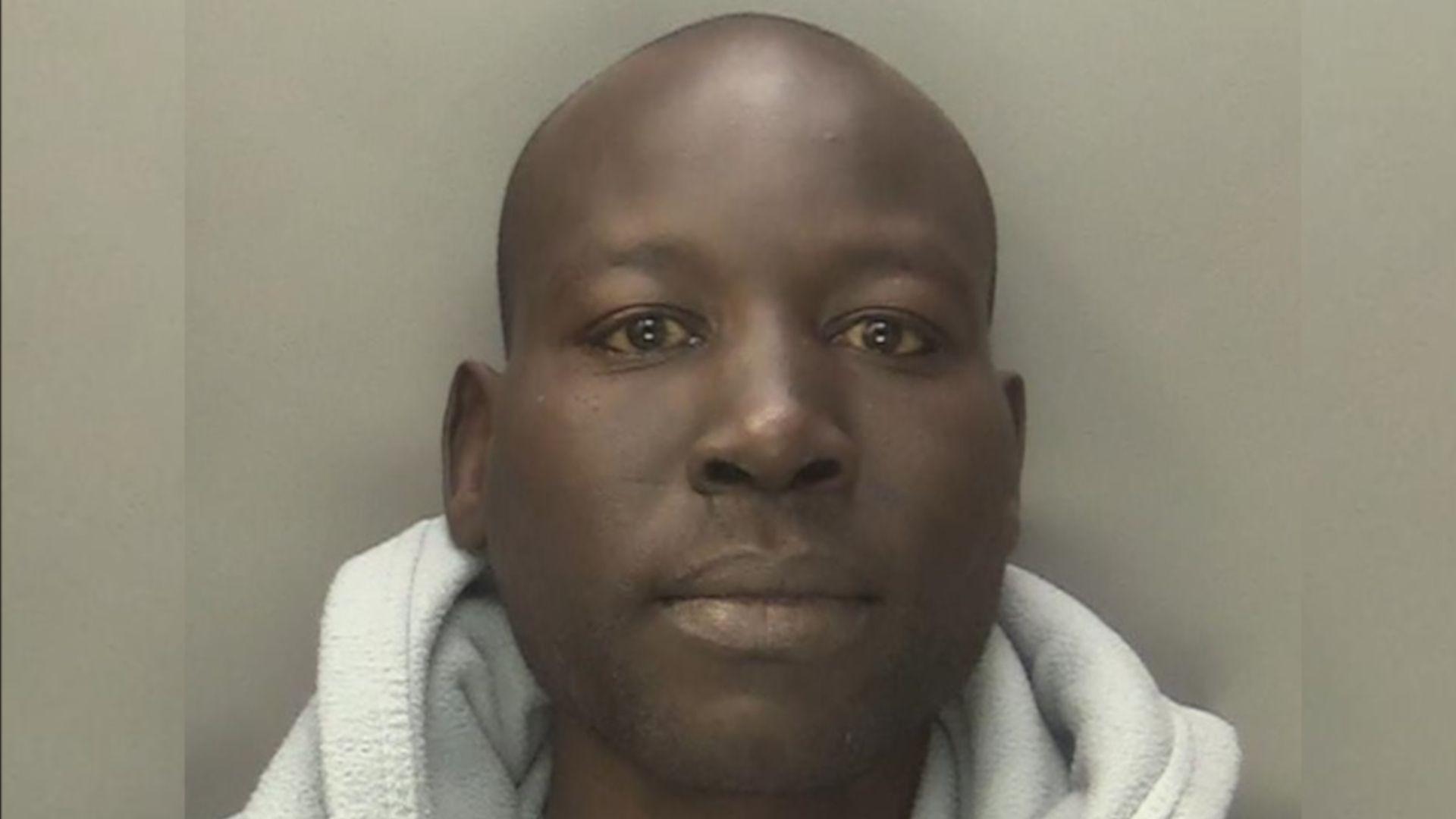 Mohammed Abdulraziq is pictured with a blank expression, wearing a grey shirt underneath a grey hoodie. He is against a grey background.