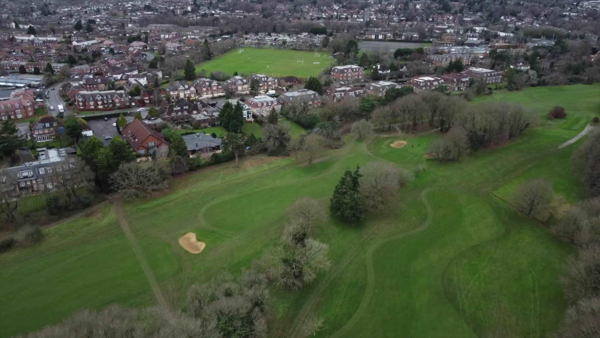 Aerial view of Maidenhead Golf Club and trees lining the golf course with houses in the background.