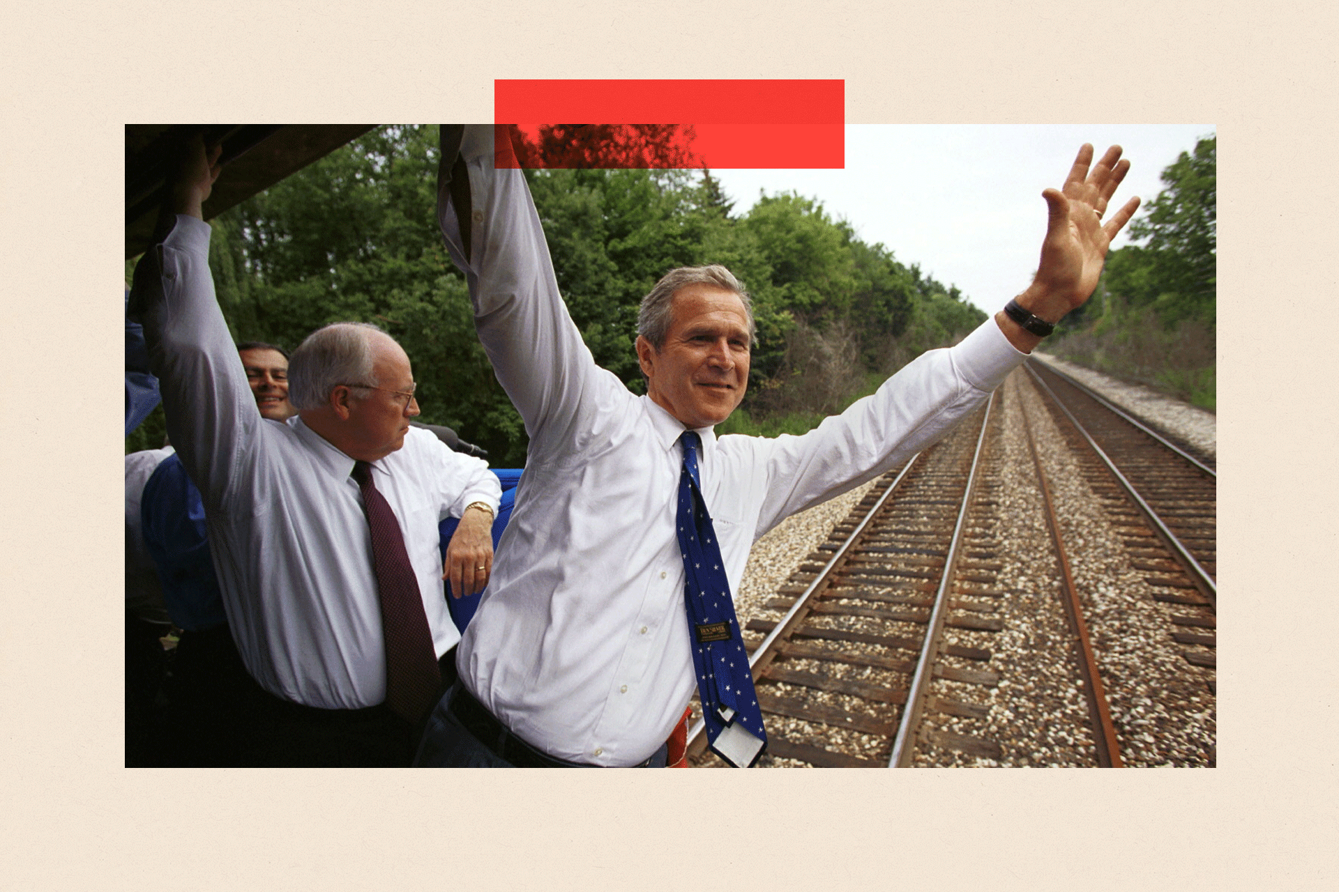 George Bush leans from a train; Dick Cheney is next to him.