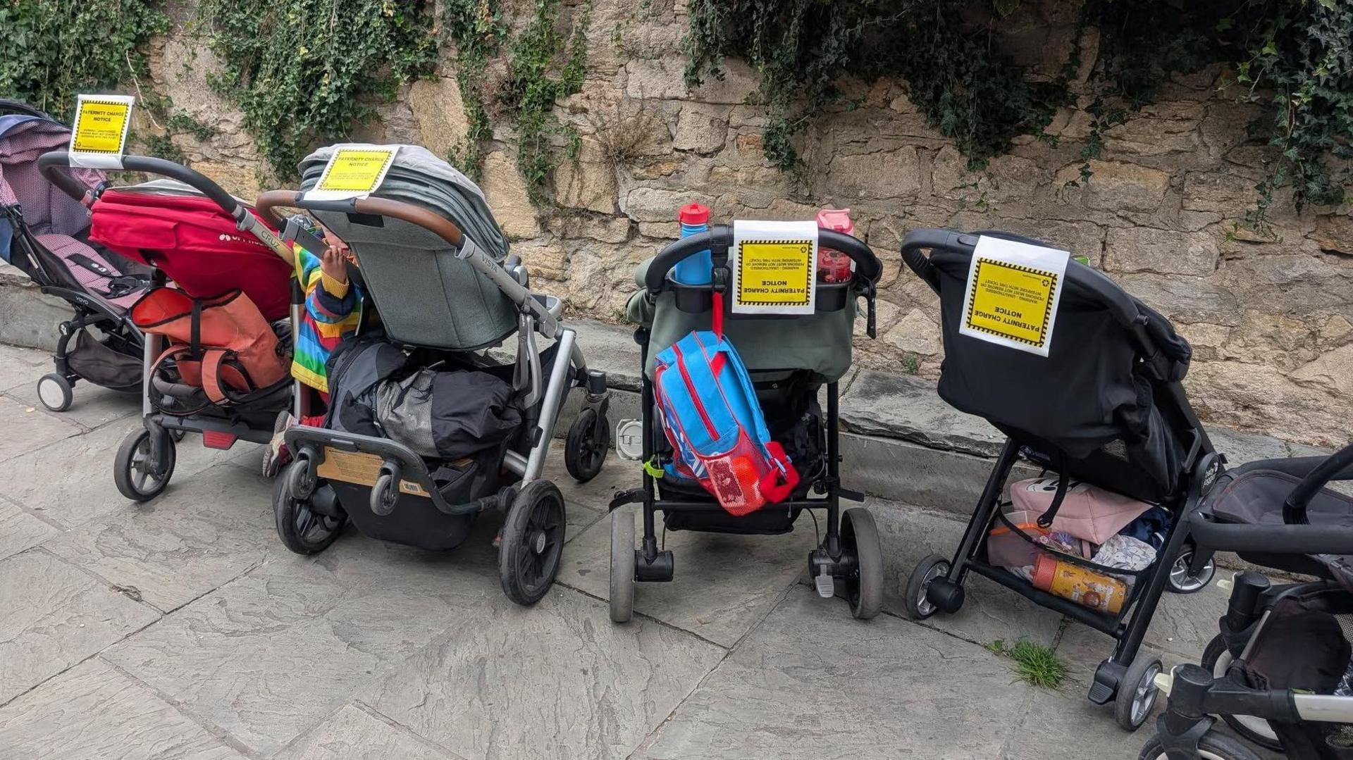 Buggies with yellow and white paternity charge notices on them raising awareness of the dad shift campaign