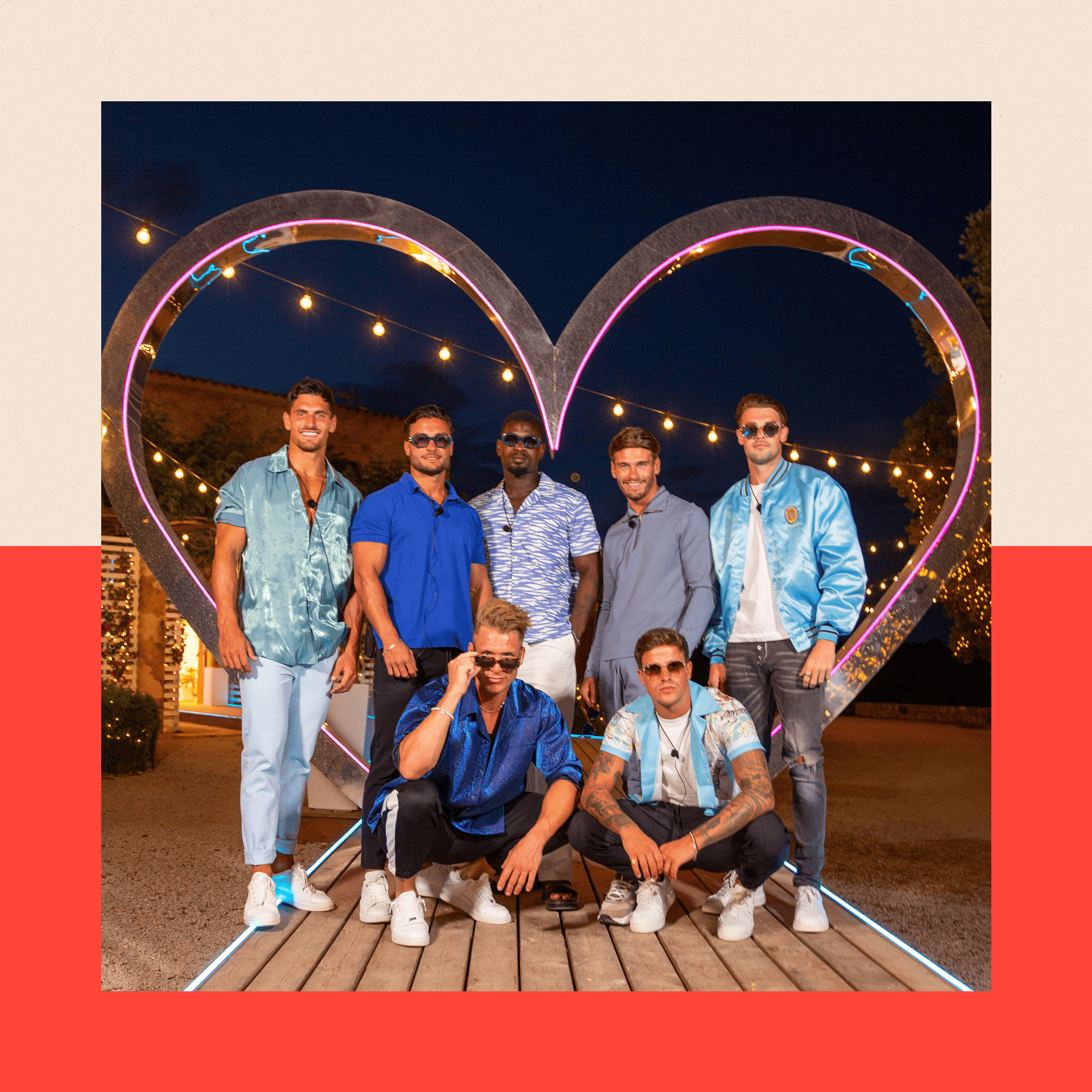 Seven Love Island contestants pose in front of a giant heart icon
