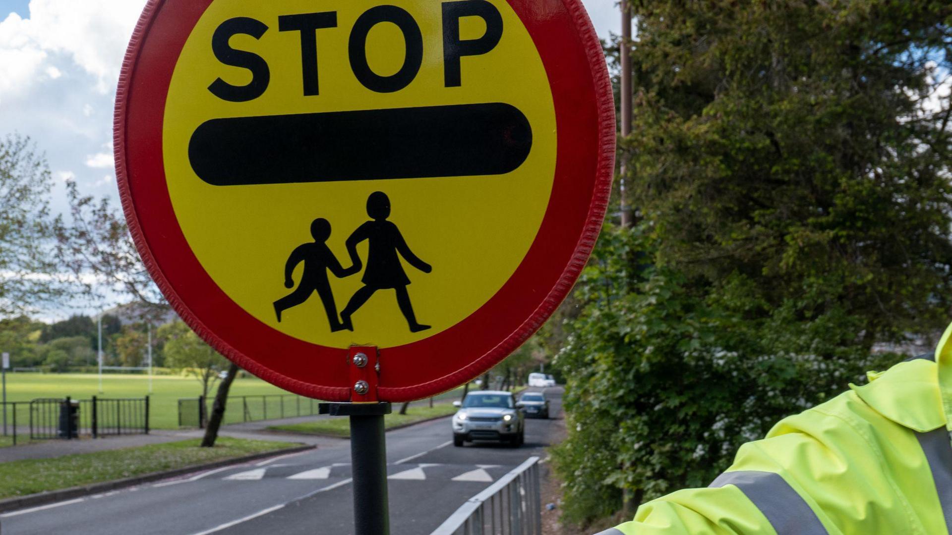 Crossing patrol officer holding crossing sign