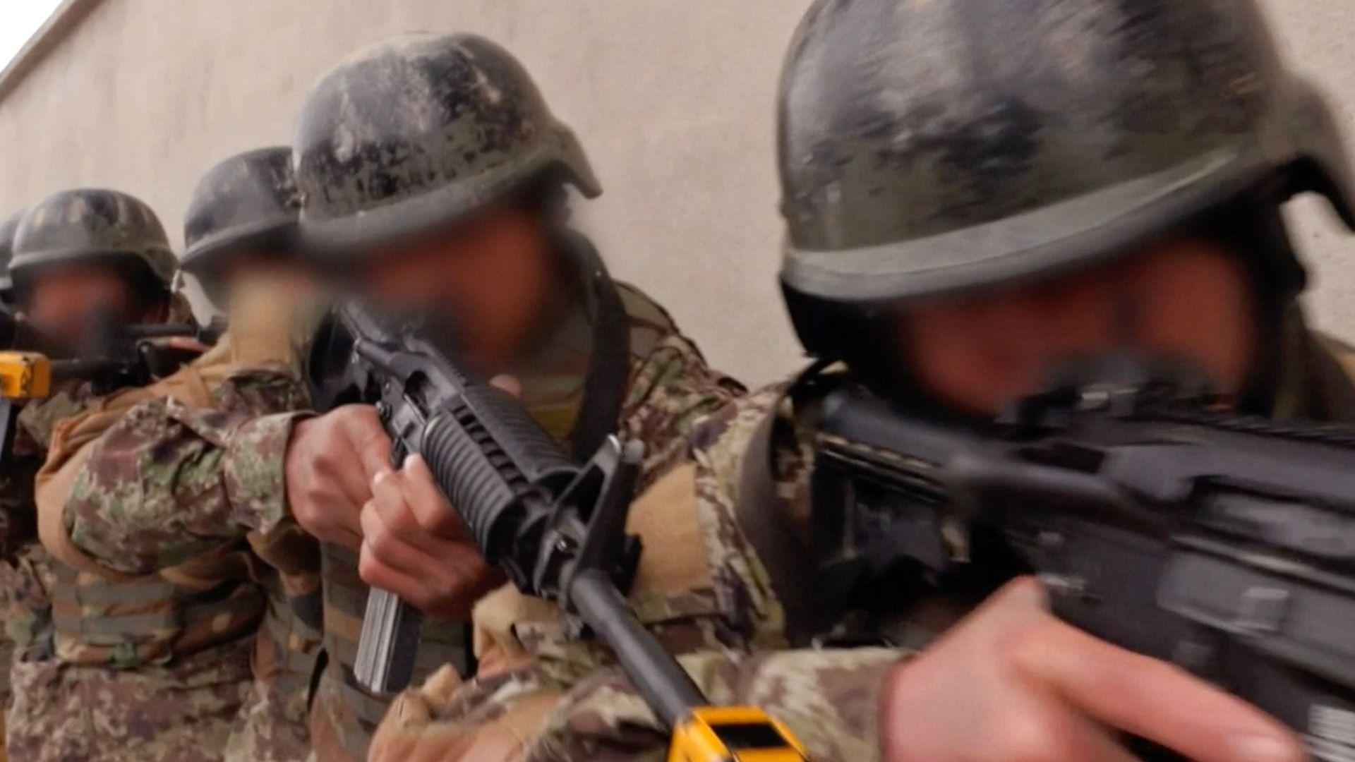 A still image from video showing Afghan special forces in camouflage aiming their weapons during what appears to be a military exercise