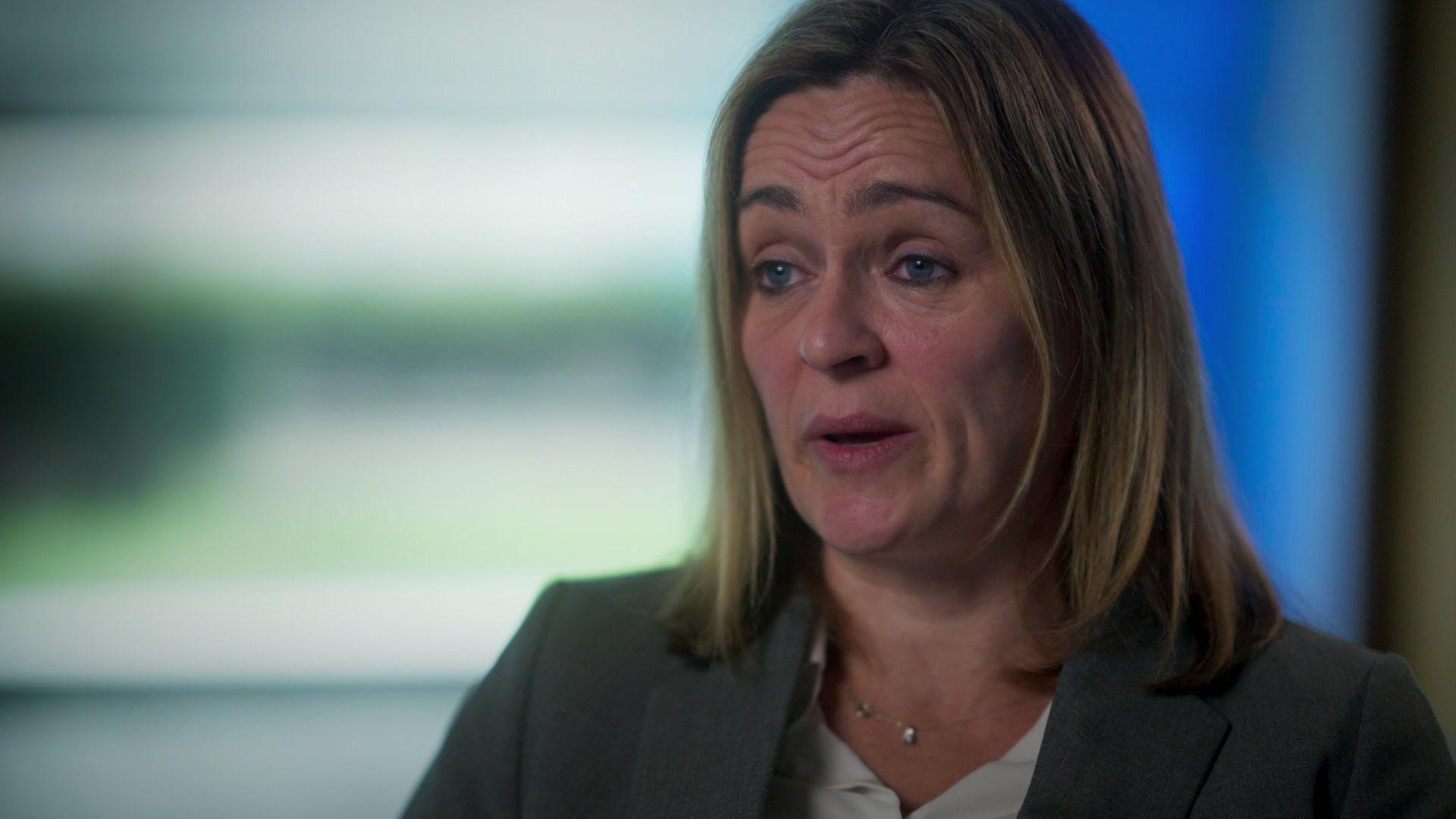 Det Insp Rachel Smith, who has shoulder length straight blonde hair, speaks to the camera while wearing a grey suit jacket over a white blouse