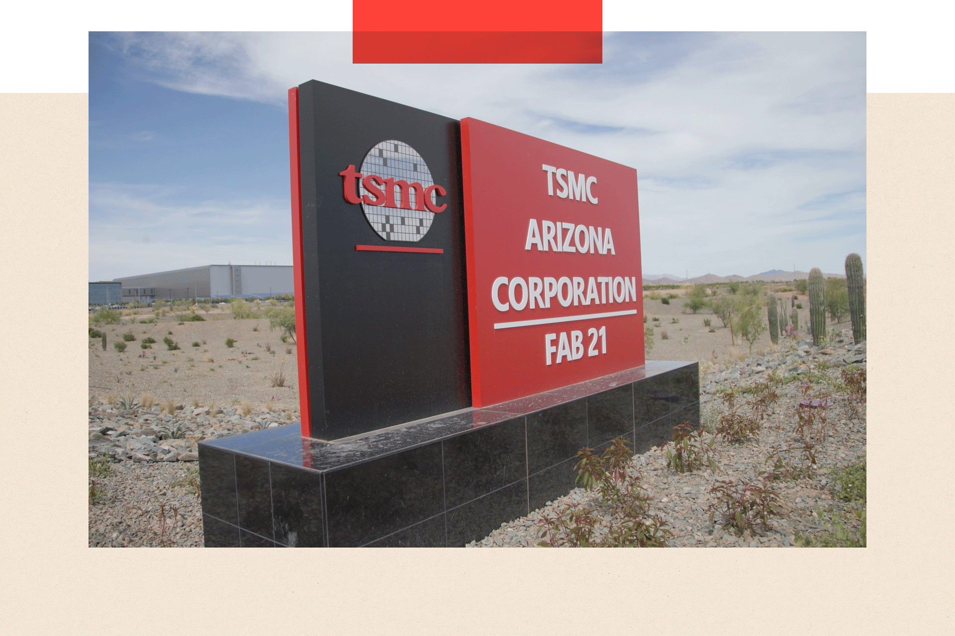 A black and red sign sits in the middle of the desert. On the sign it says 'TSMC Arizona, Corporation, Fab 21'.