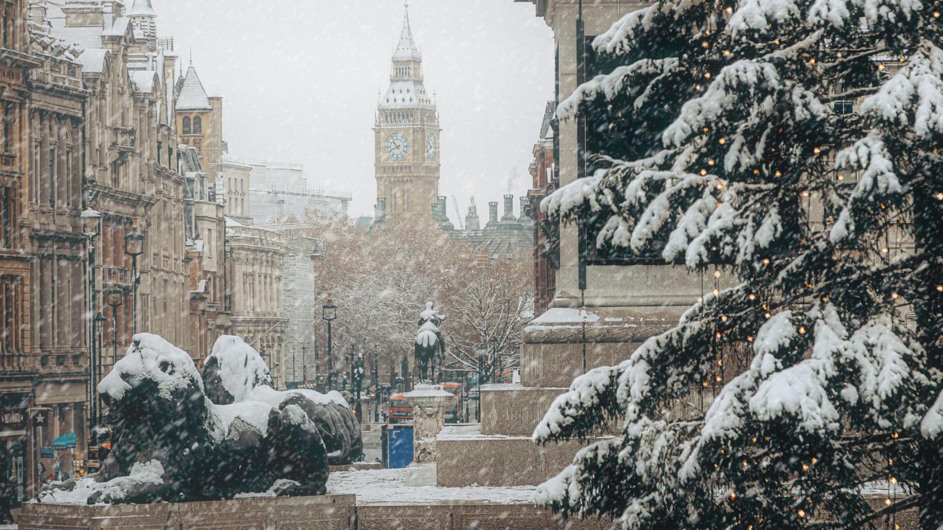 View of a very snowy central London, with the lions in Trafalgar Square covered in snow and a snowy Christmas tree