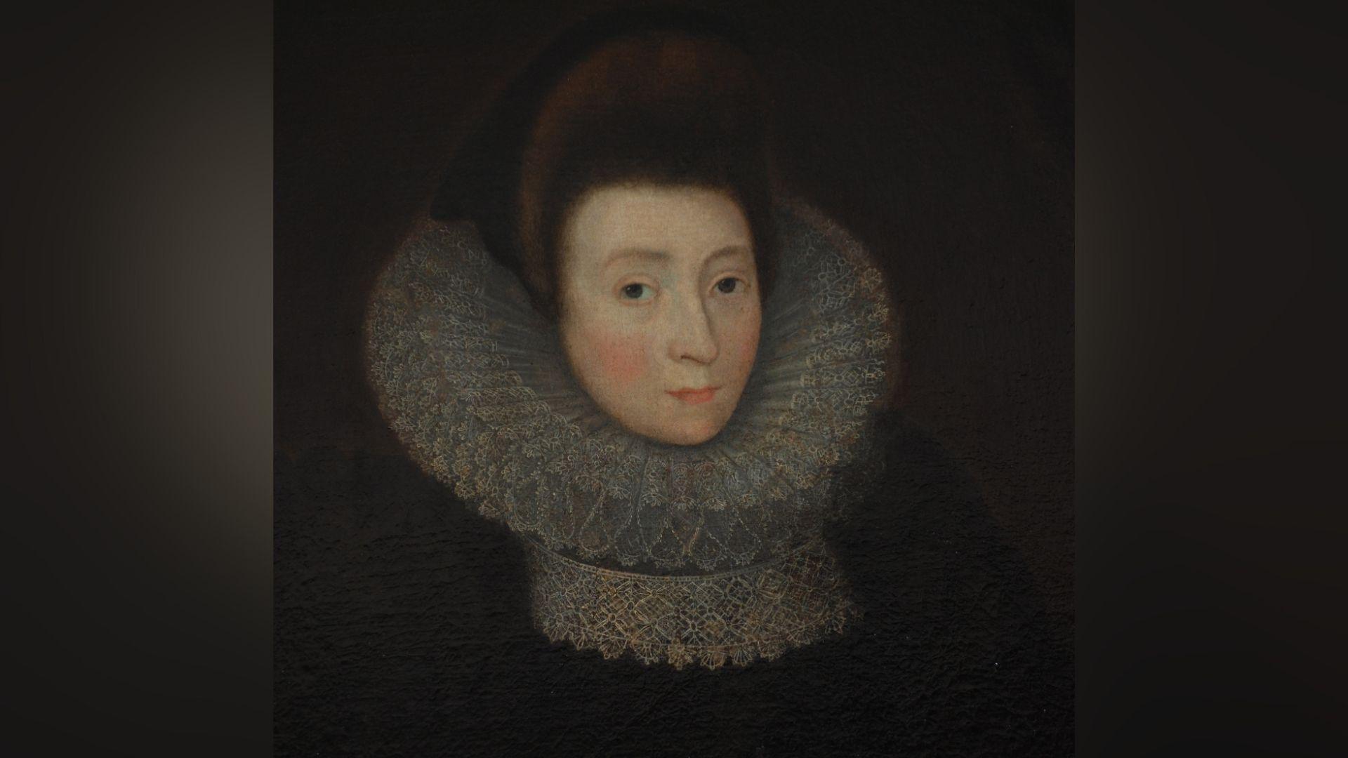 A painted portrait of Anne Griffith. She has dark brown hair in an Elizabethan-era updo style. She has a large, white ruffled collar on and is wearing a black dress. She is pale with brown eyes.
