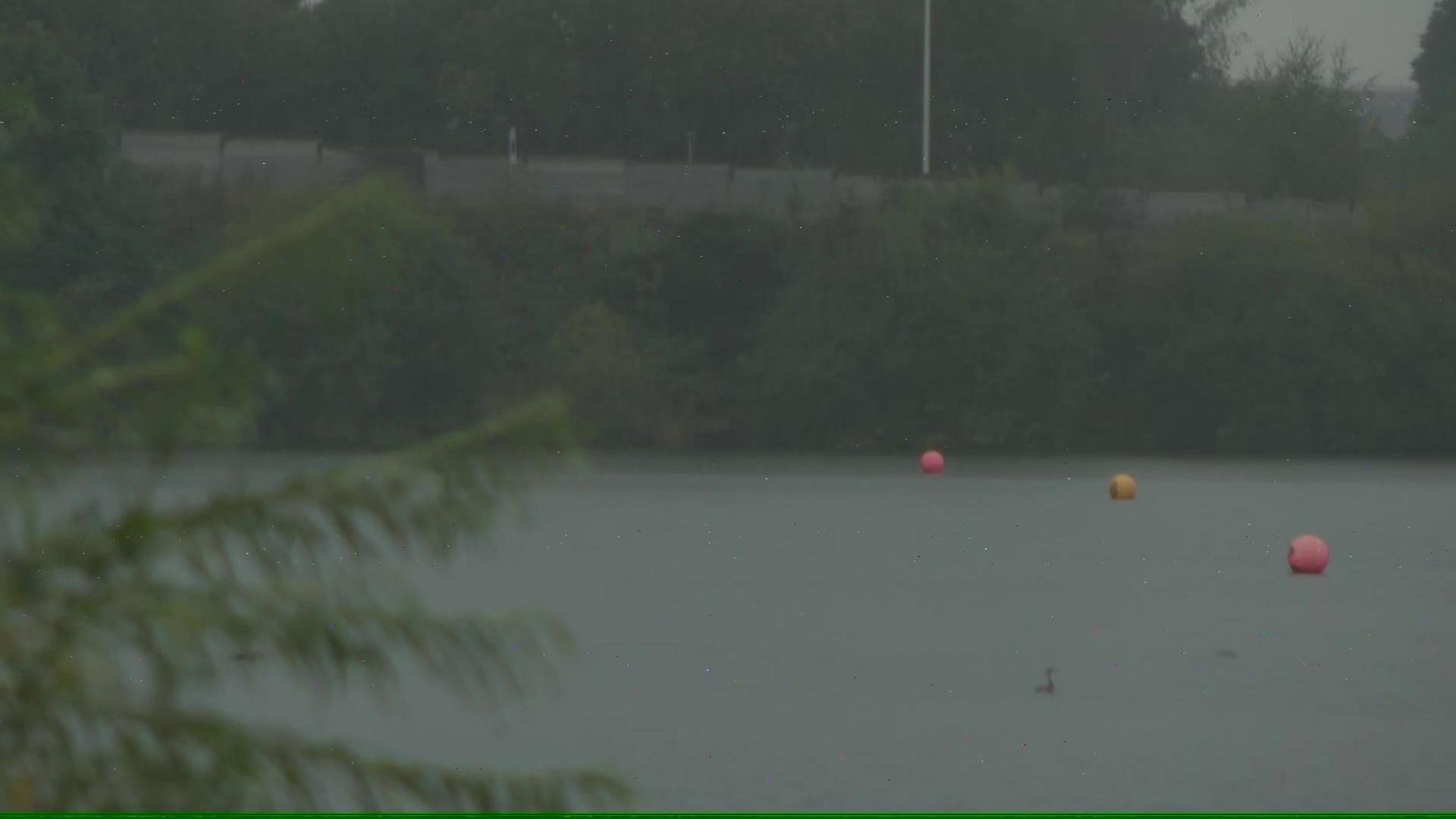 Yellow and pink buoys on Scotsmans Flash lake in the rain