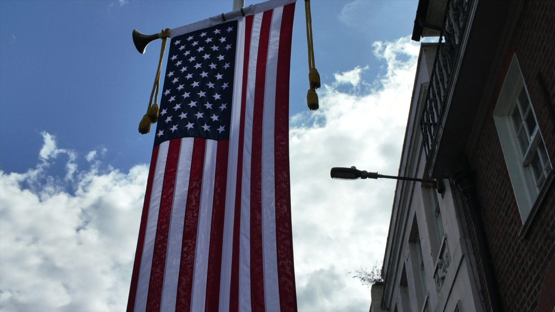The Stars and Stripes flag hanging vertically from a flag pole outside a building just a hundred yards or so from Windsor Castle.