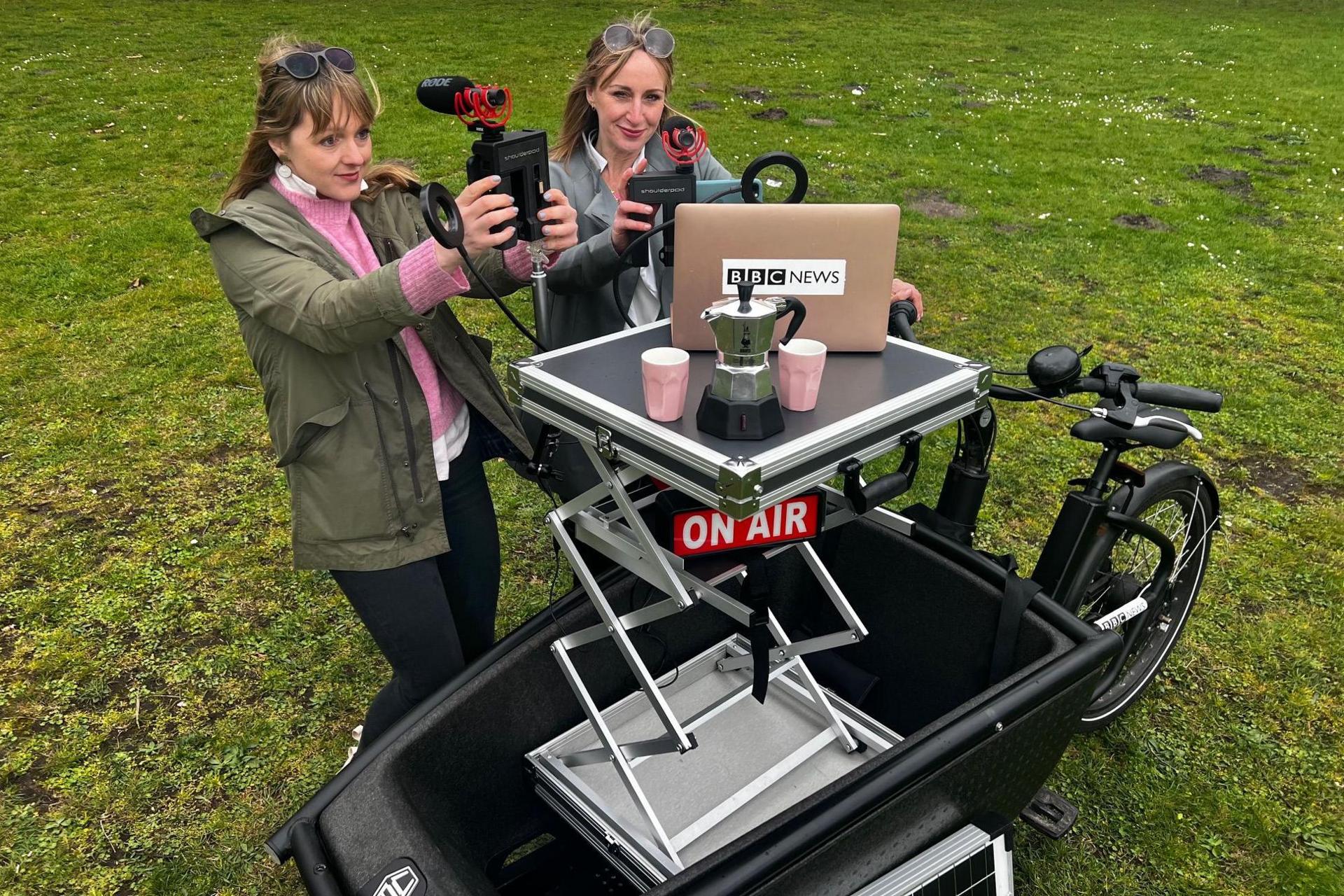 A cargo bike with a retrofitted table, laptop, microphones and an 'on air' sign - a mobile broadcast studio on a bike that could be used by the BBC.