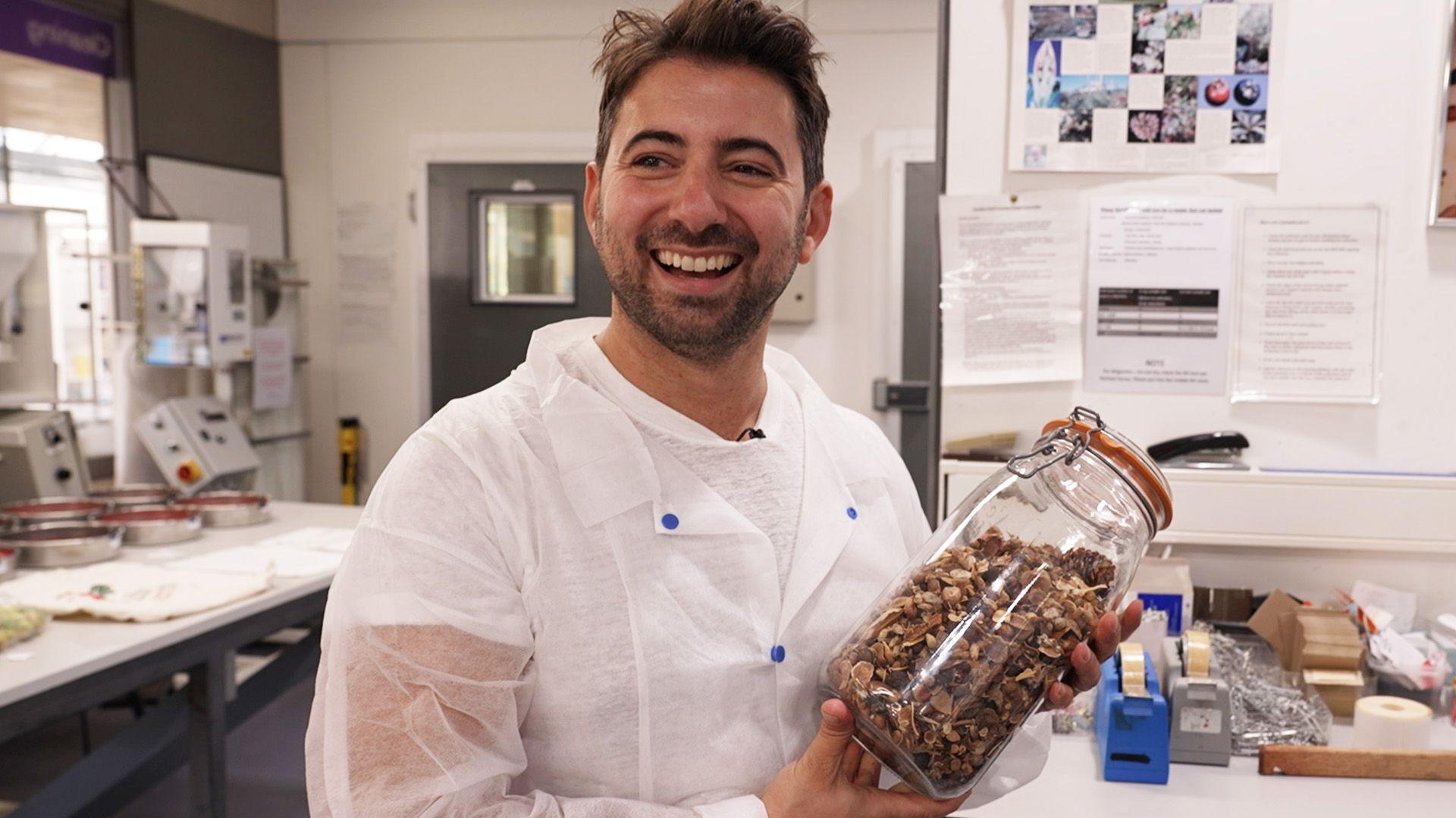 Ricky laughing as he holds a jar of seeds