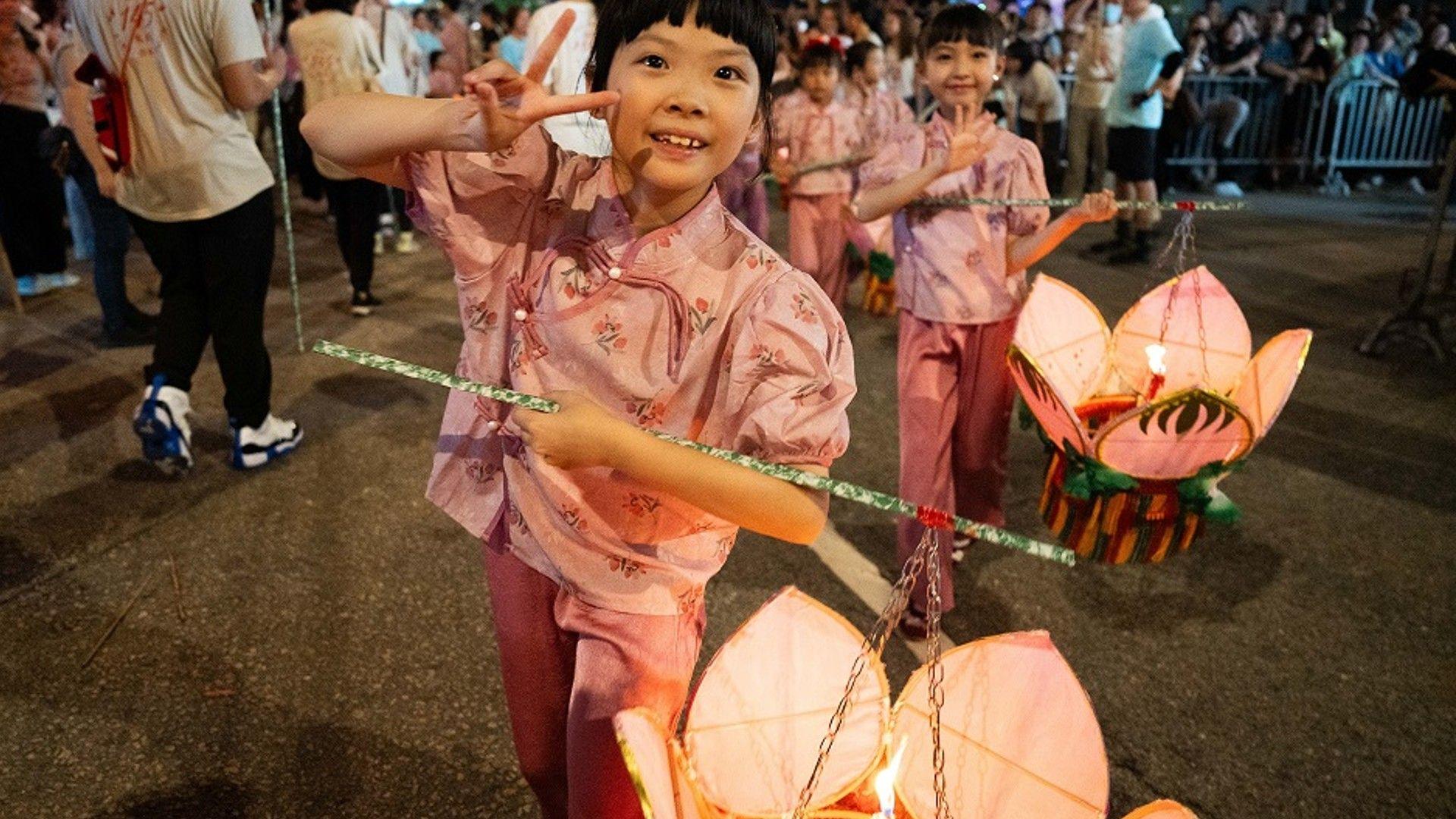 Girls carrying lanterns during festival. 