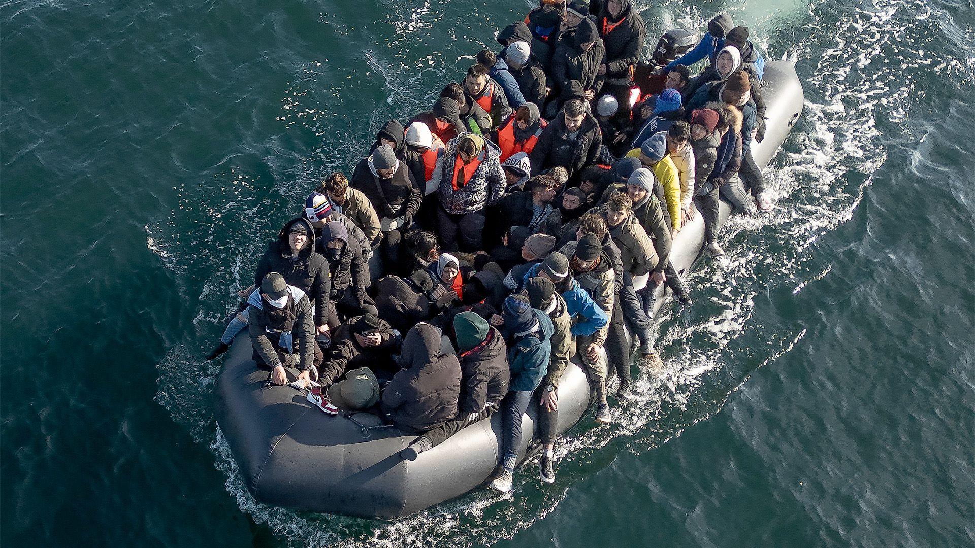 Dozens of migrants, mainly men, crammed into a inflatable dinghy.