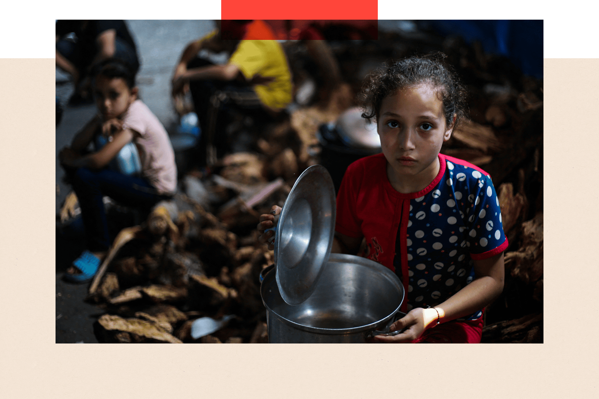 Palestinian children wait for food at a distribution point in Nuseirat, central Gaza Strip