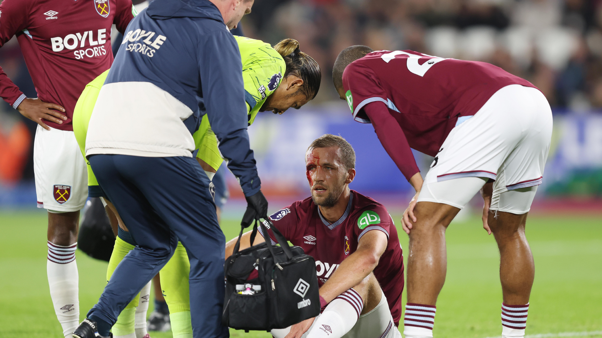 West Ham's Tomas Soucek sits on the pitch with blood on his forehead receiving medical attention