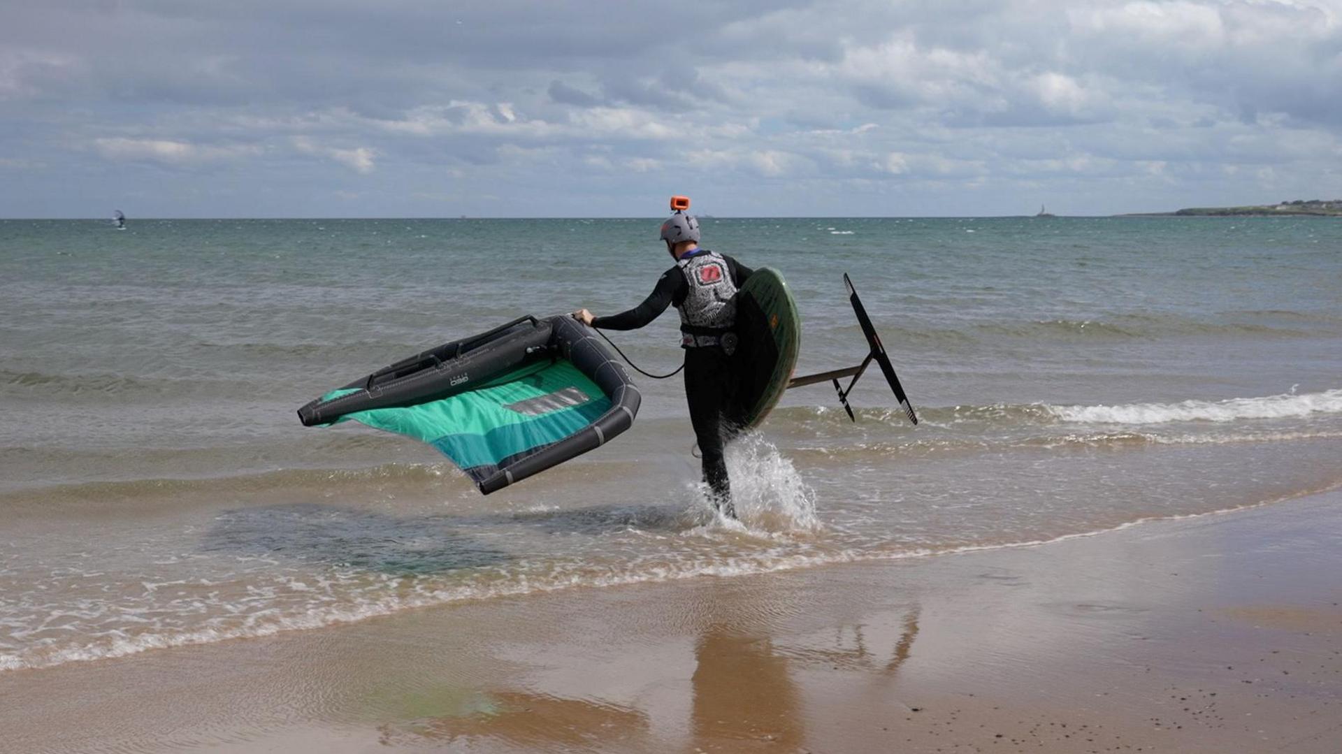 A kite surfer entering the water at Blyth