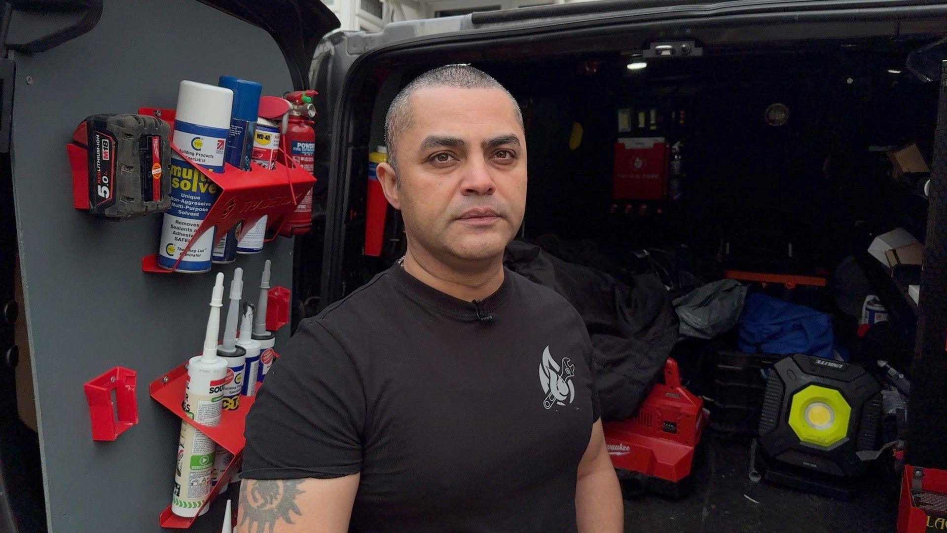 Gas fitter standing in front of his work van.