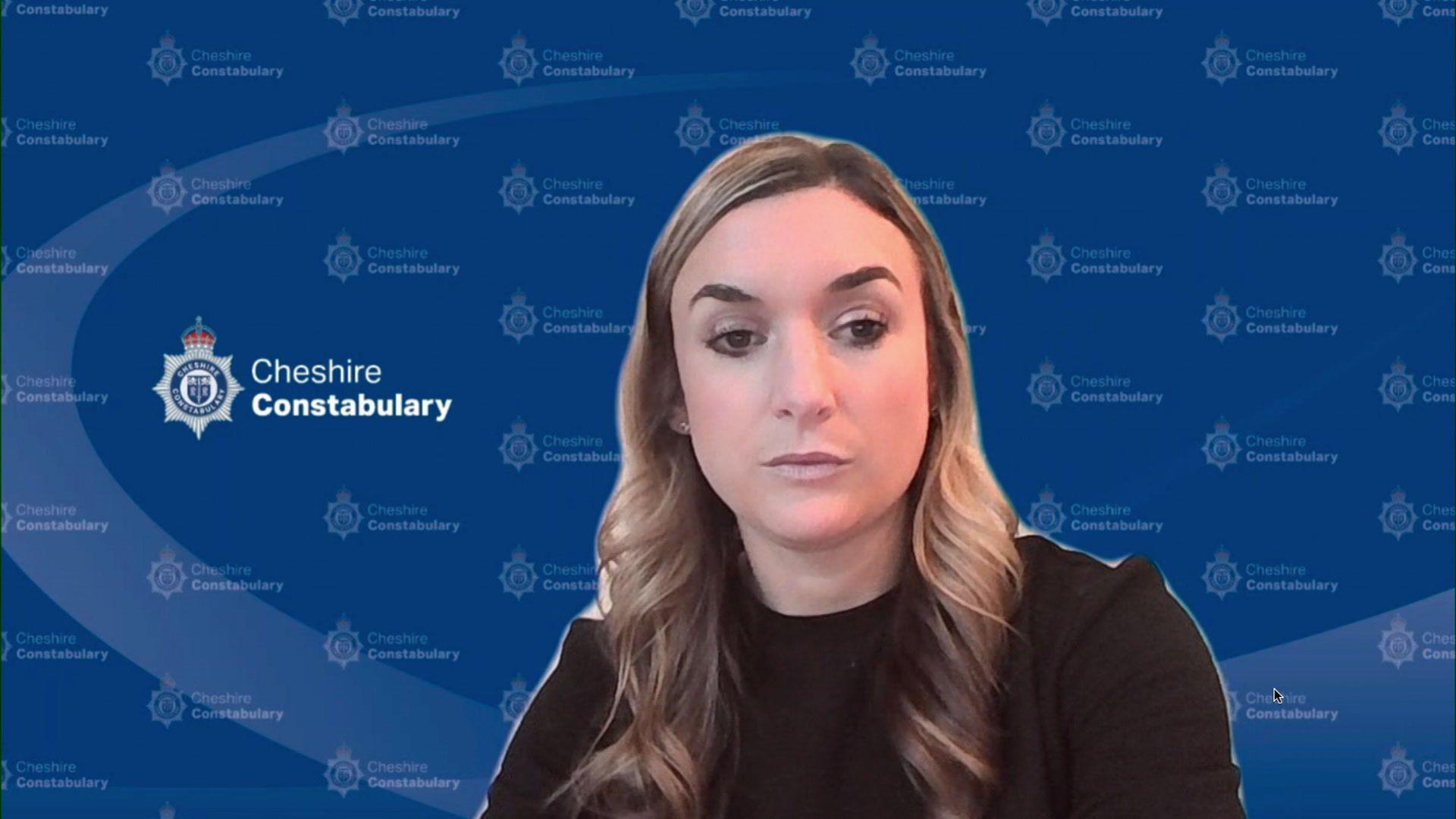 Ch Insp Amber Hodson, who has blonde wavy hair, looks into the camera with a serious expression. In the background is a blue screen displaying a Cheshire Police crest.