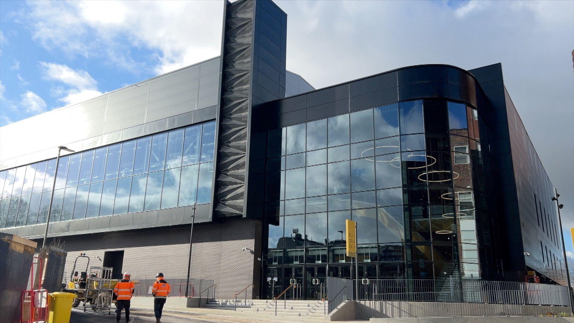 The outside of Becketwell Live arena which has a dark exterior and many glass windows