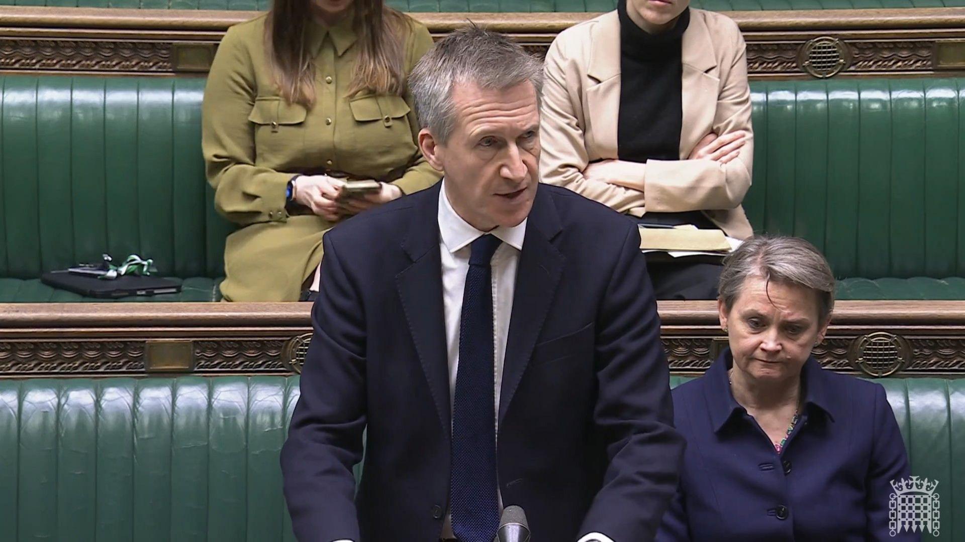 Dan Jarvis wearing a suit while speaking in the House of Commons. He is standing at the despatch box and Yvette Cooper is sitting behind him on the green front bench.