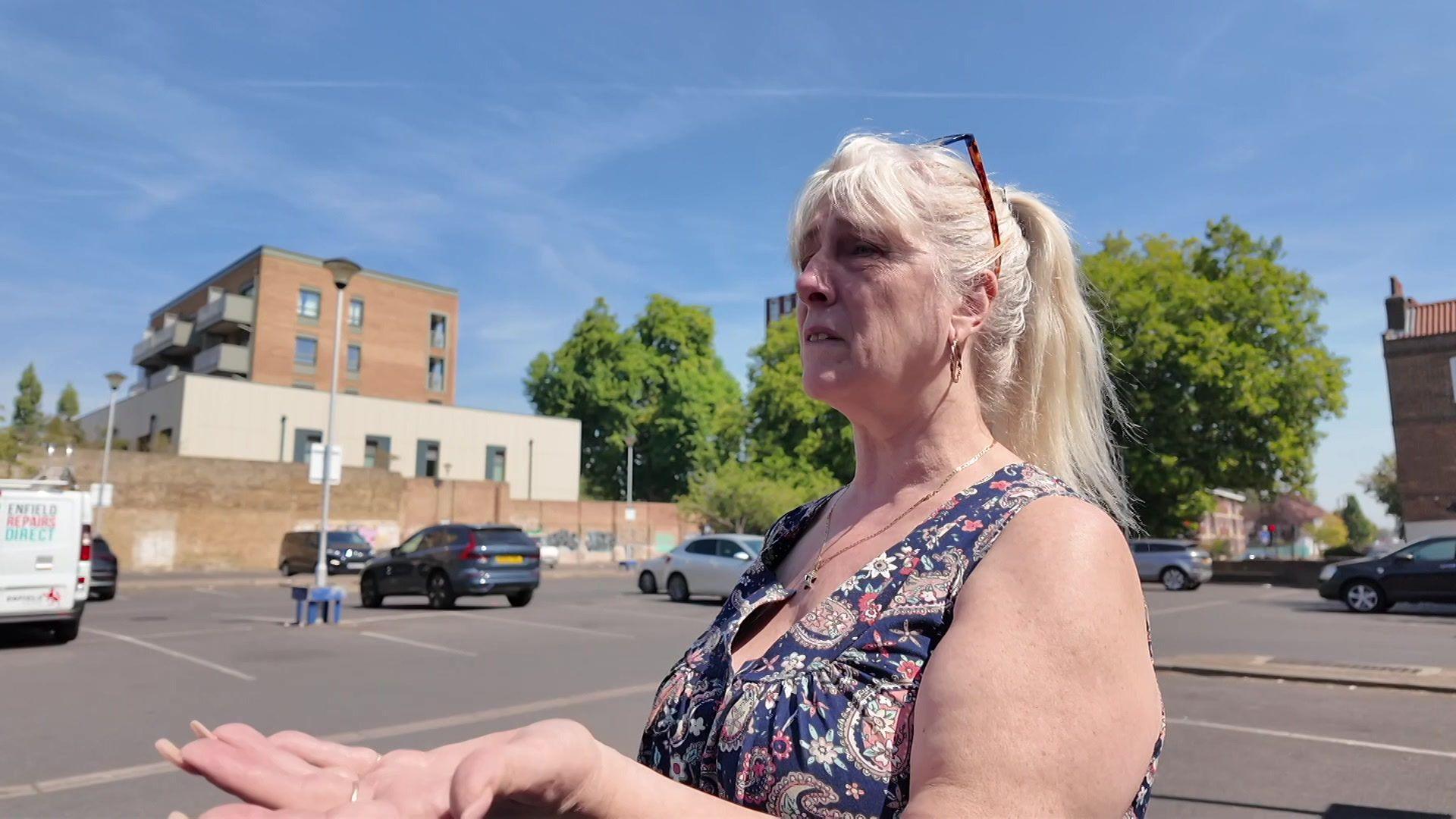 Tina Chisholm, a middle-aged woman with long blonde hair, stands in a car park
