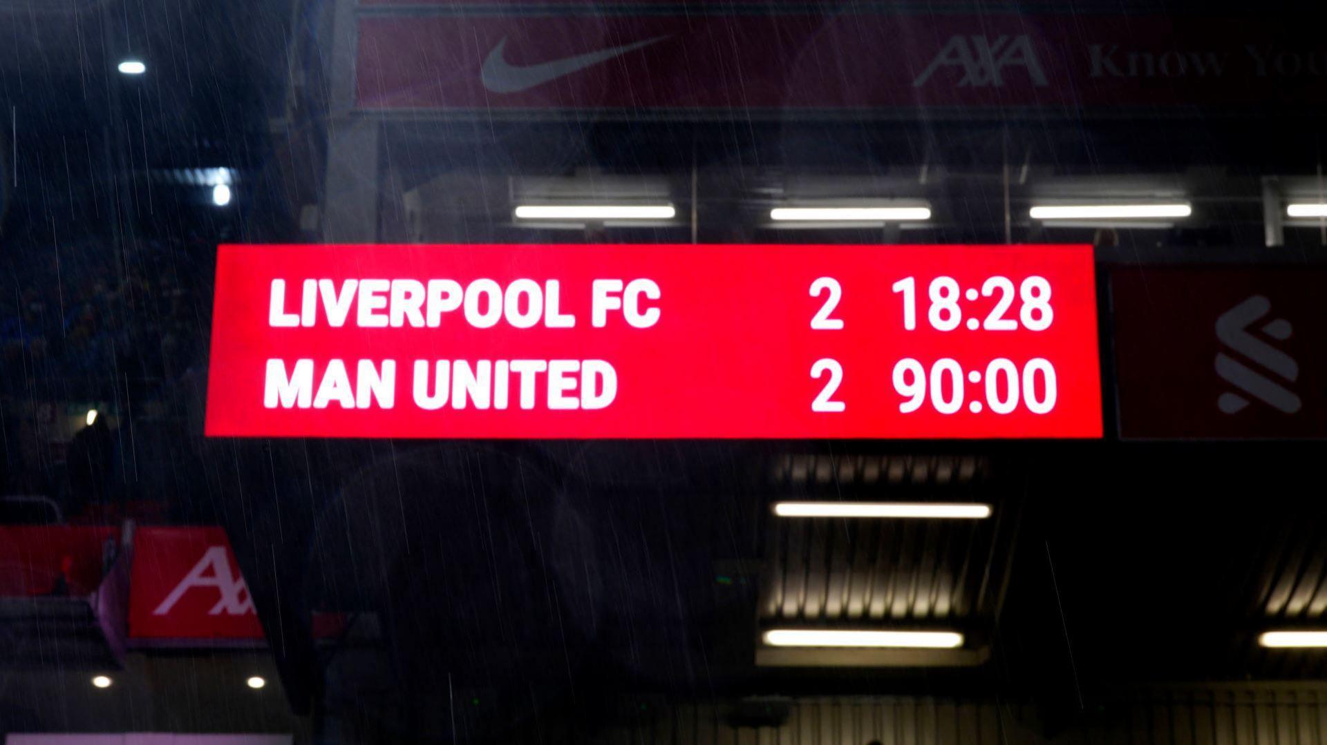 Scoreboard with white text on a red background reads "Liverpool FC 2 Man United 2".