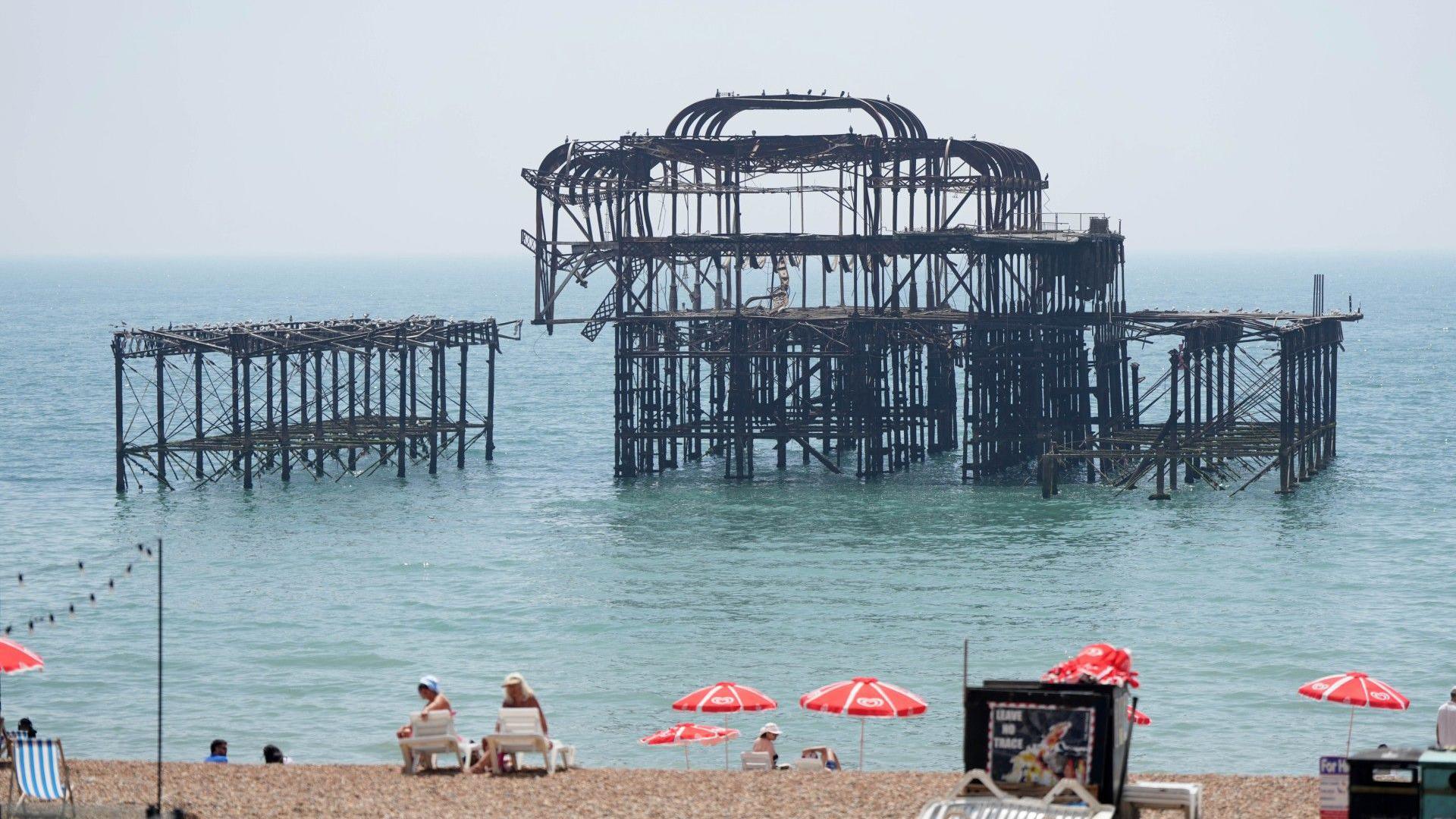 The metal shell of a derelict Victorian pier out at sea. 
