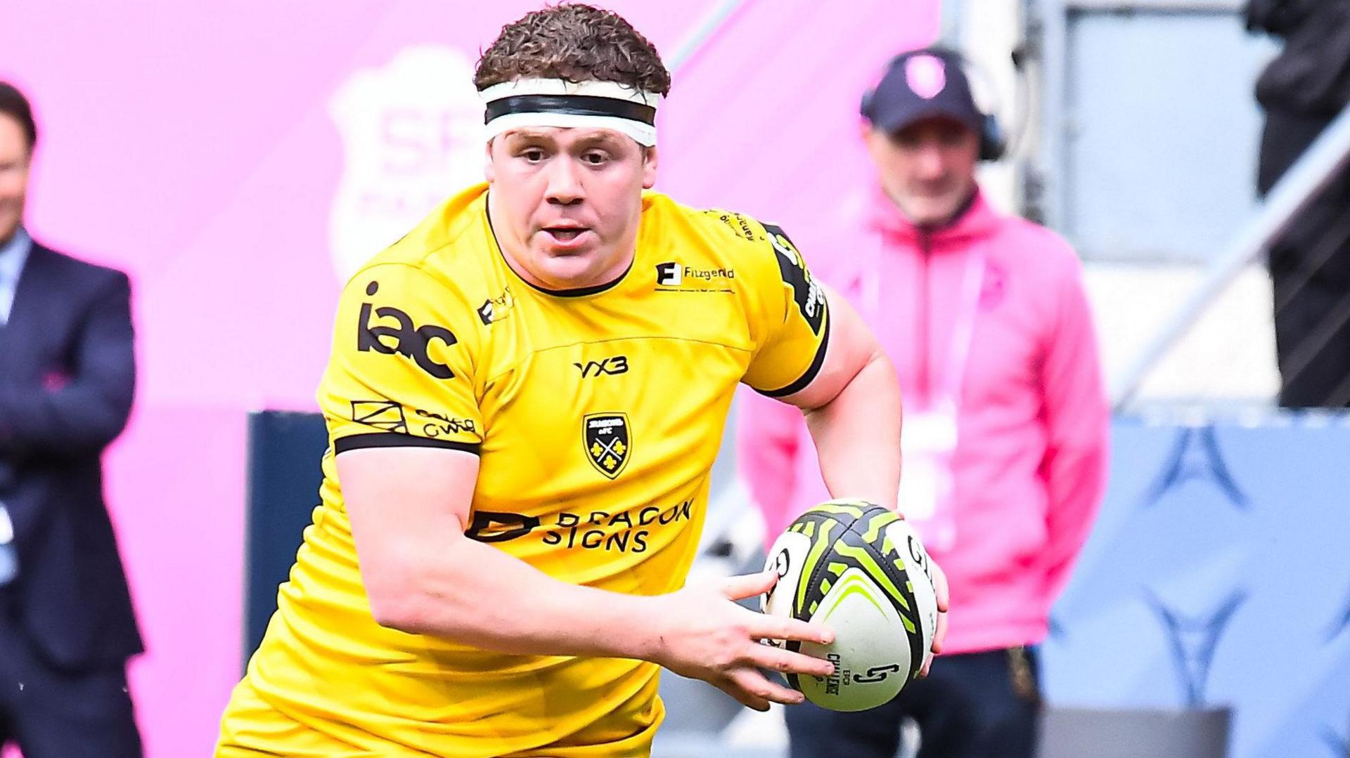 Brodie Coghlan in action with rugby hall in hand