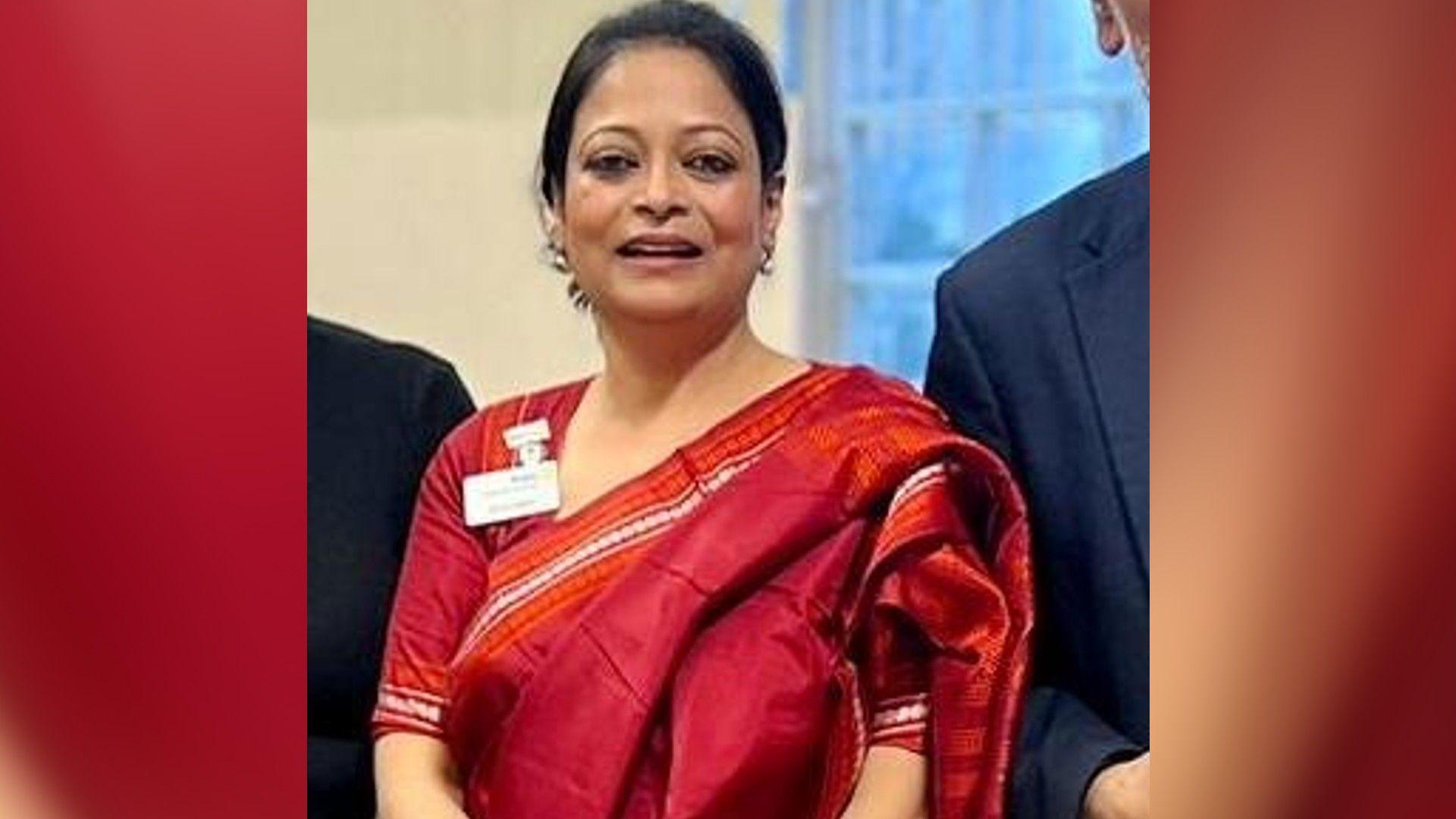 Annamika in a red saree smiling for the camera