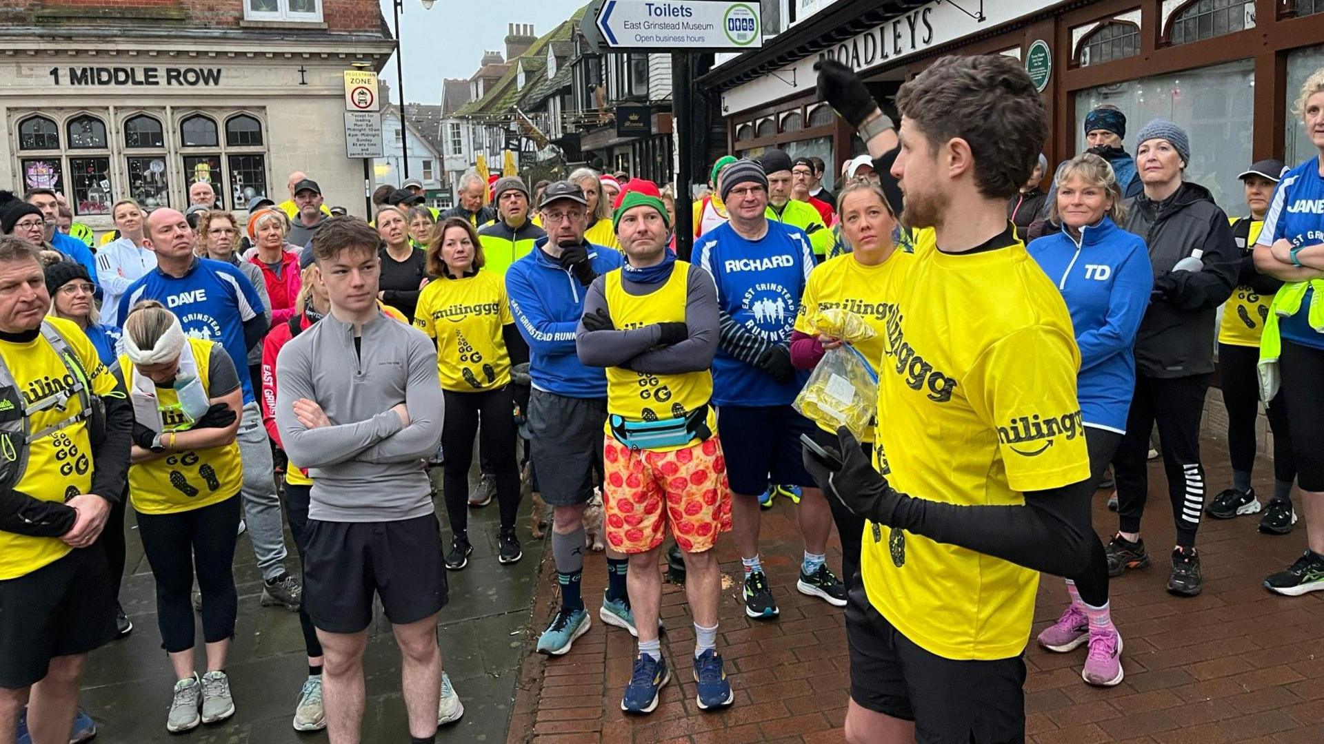 James Cooper surrounded by other runners, all wearing running gear, in East Grinstead.