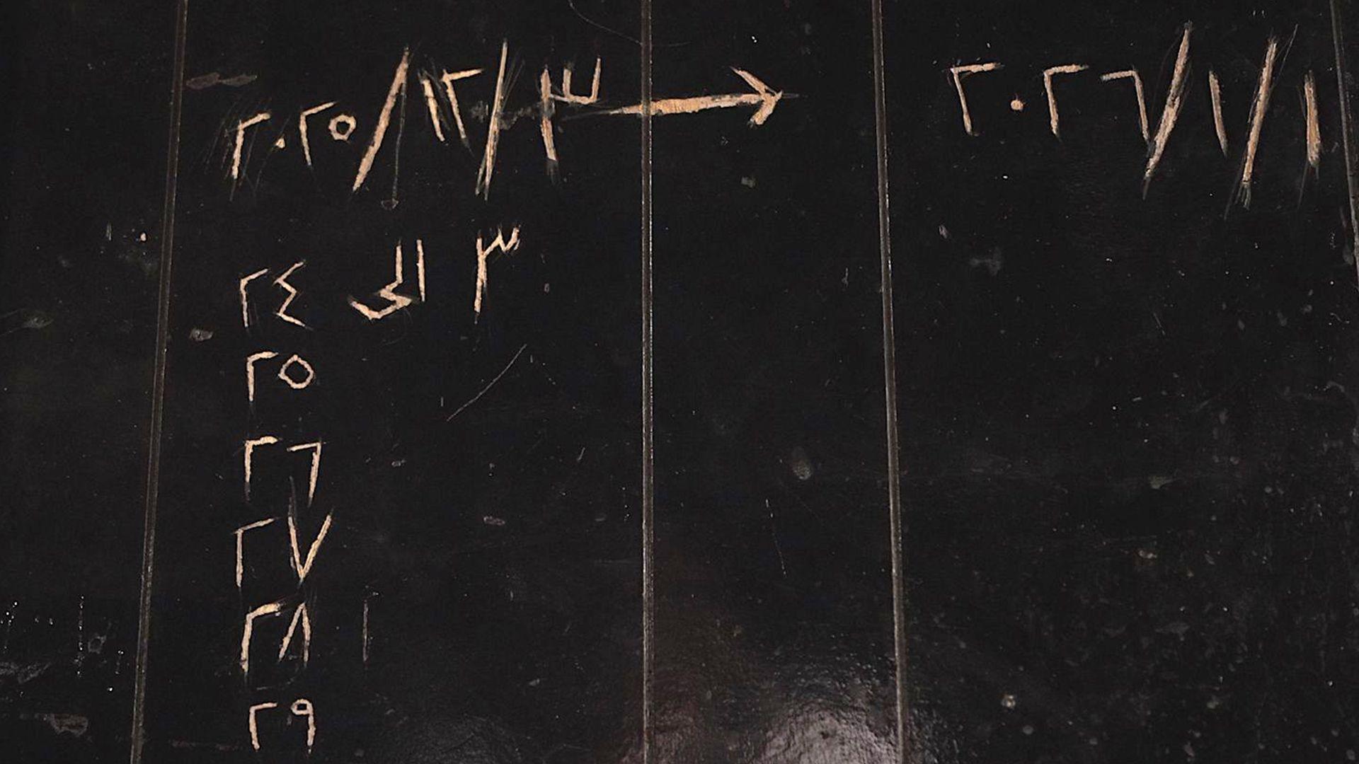 Mur i lyer me të zezë me data të gdhendura në arabisht